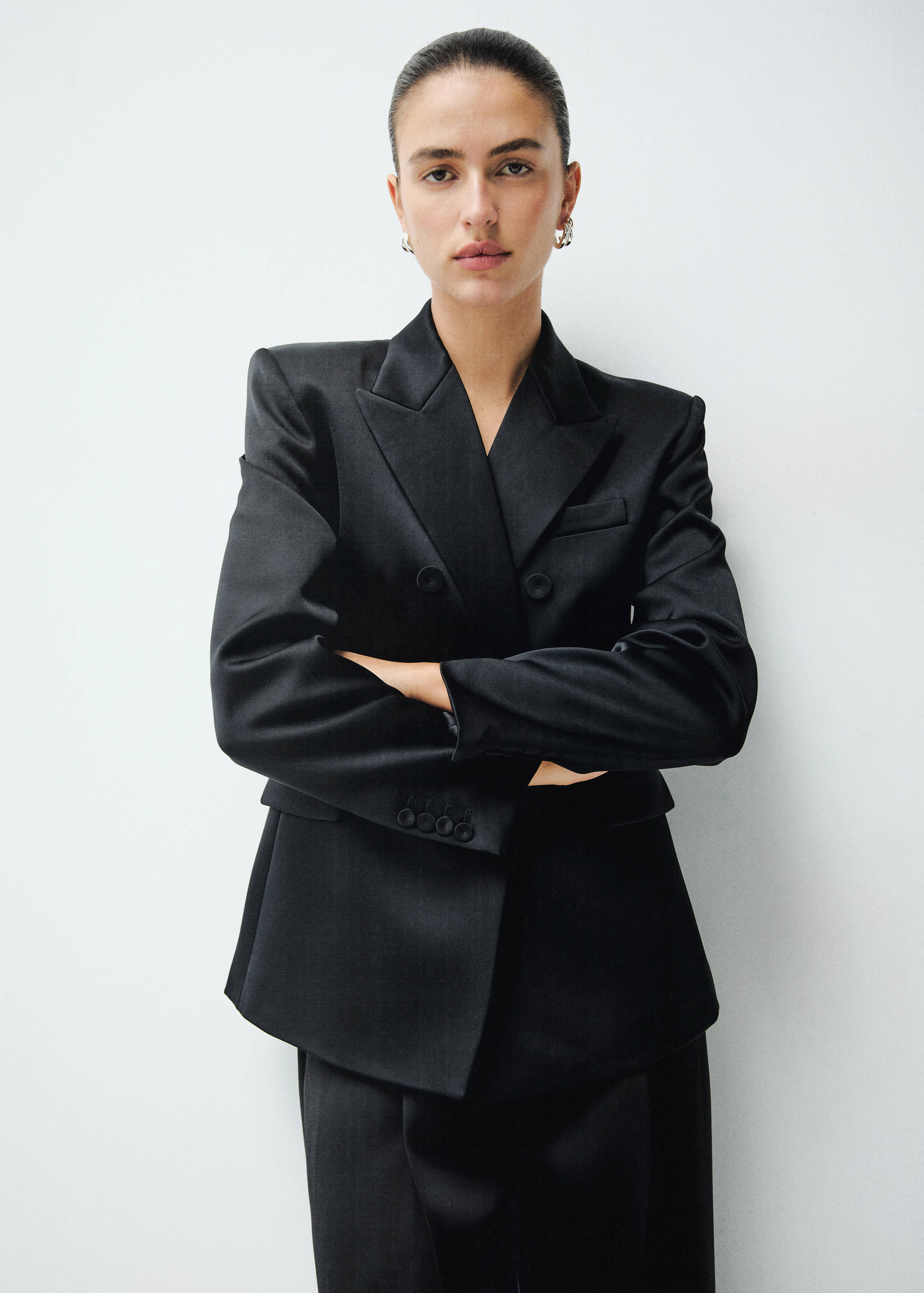 Black double-breasted blazer with structured shoulders and peak lapels.