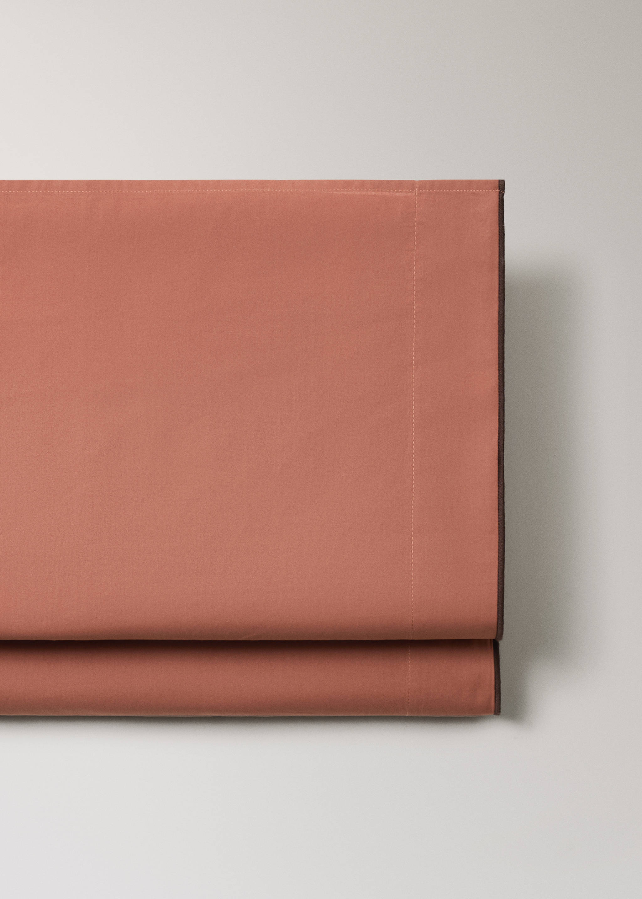 Terracotta flat sheet with stitched top hem and contrasting piping detail.