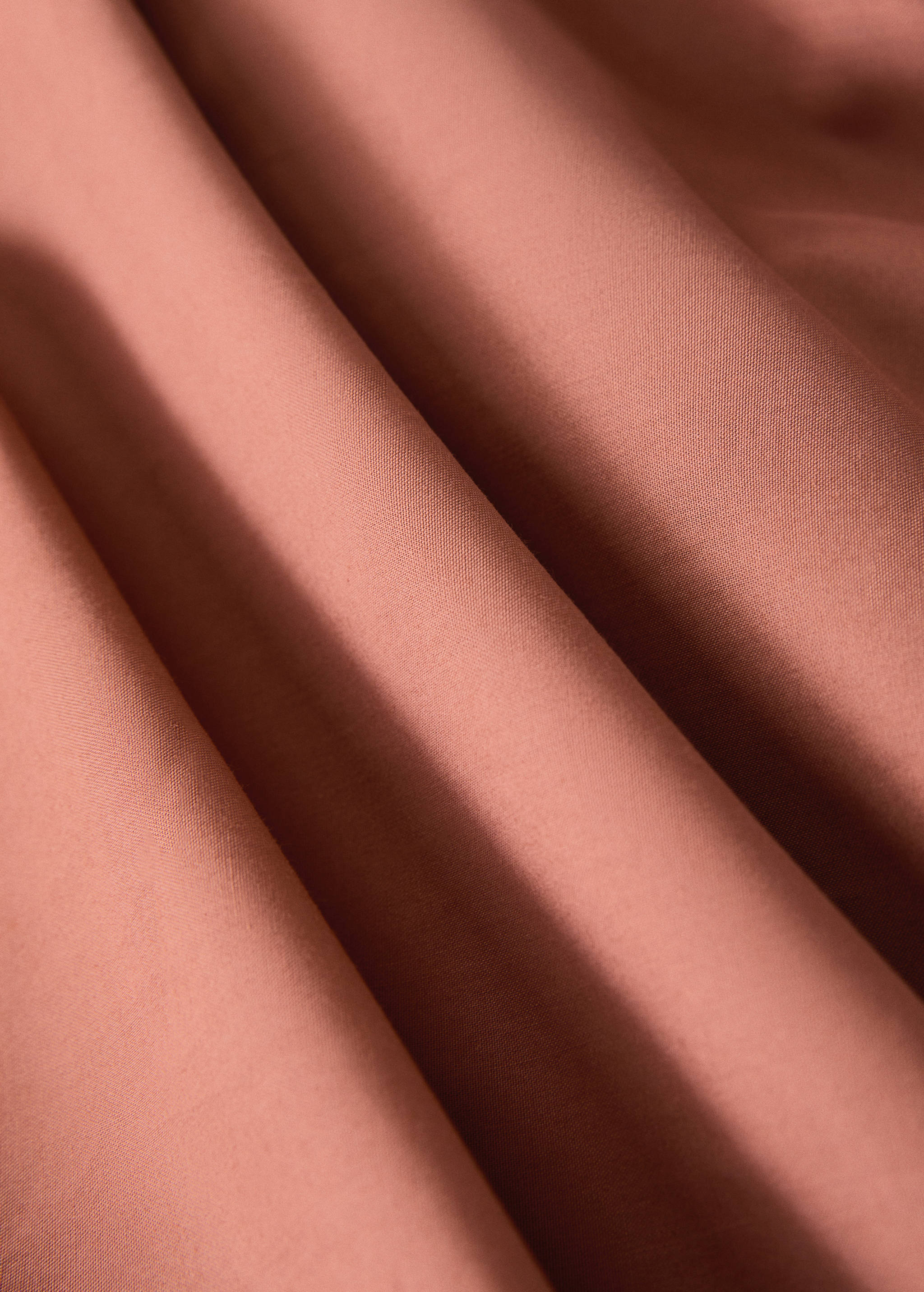 Pink flat sheet in a soft fabric texture close-up.
