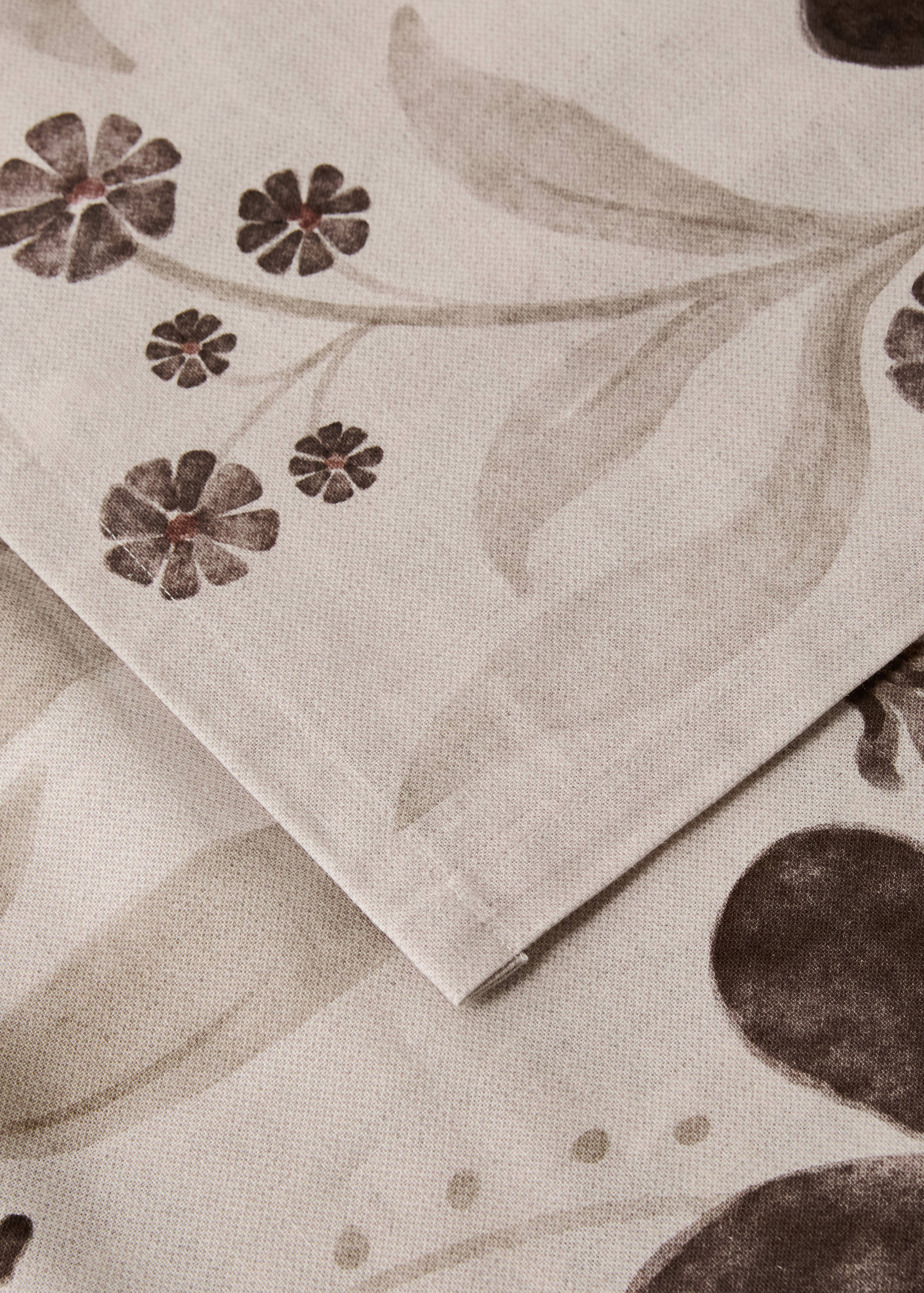 Beige tablecloth with a brown floral and botanical print.