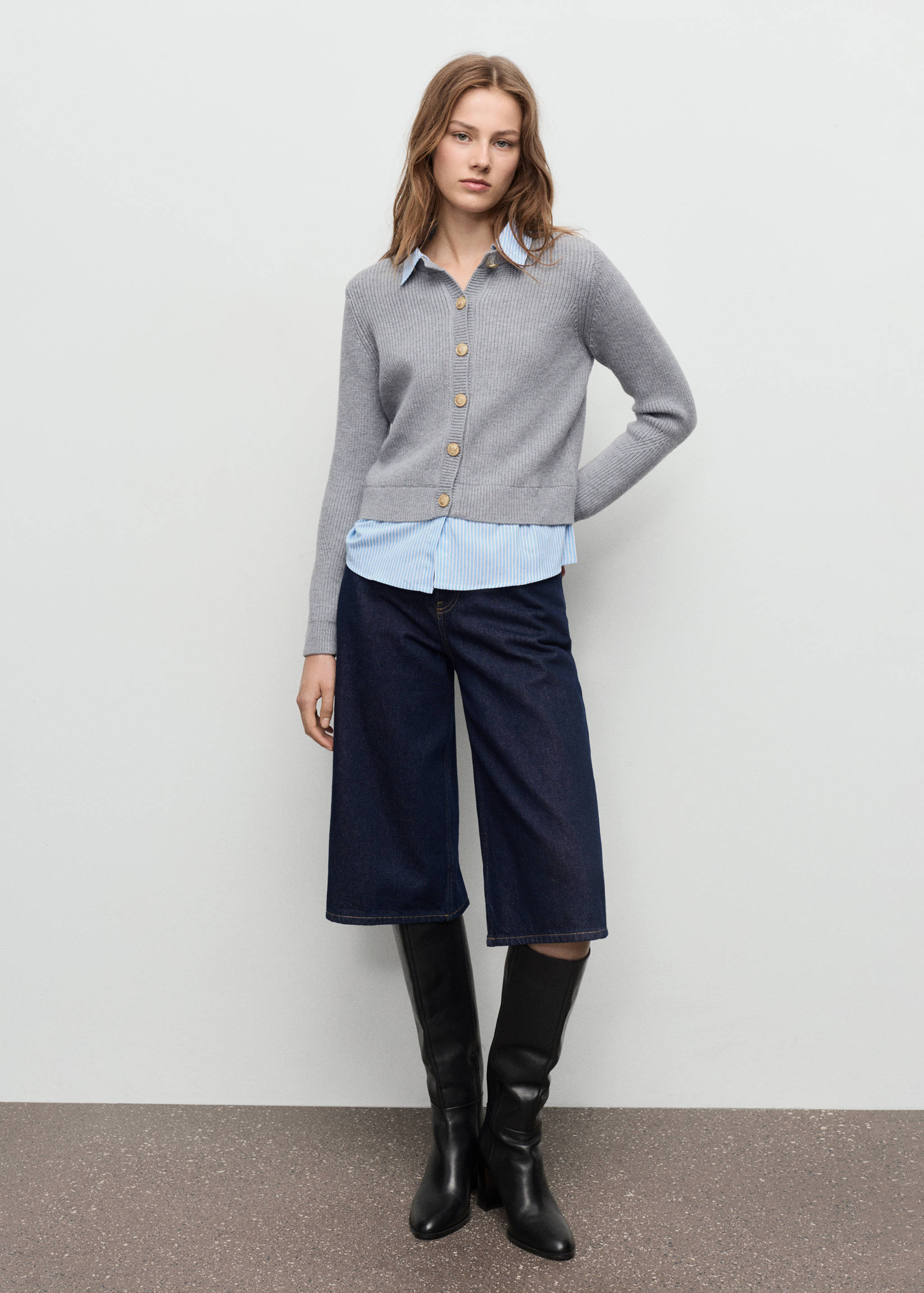 Grey ribbed knit cardigan worn over a striped shirt with dark denim culottes.