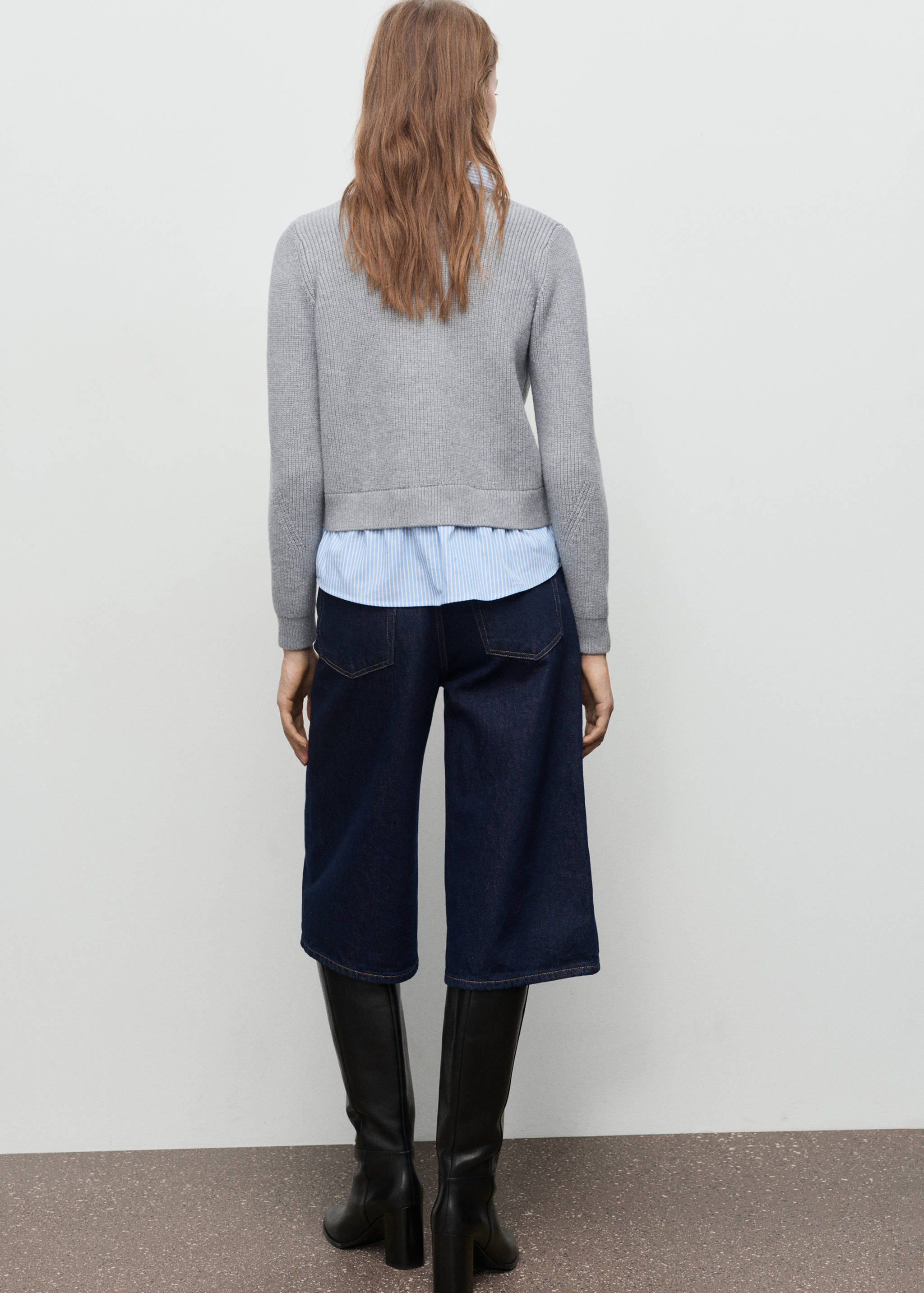 Back view of a grey ribbed knit cardigan layered over a striped shirt.