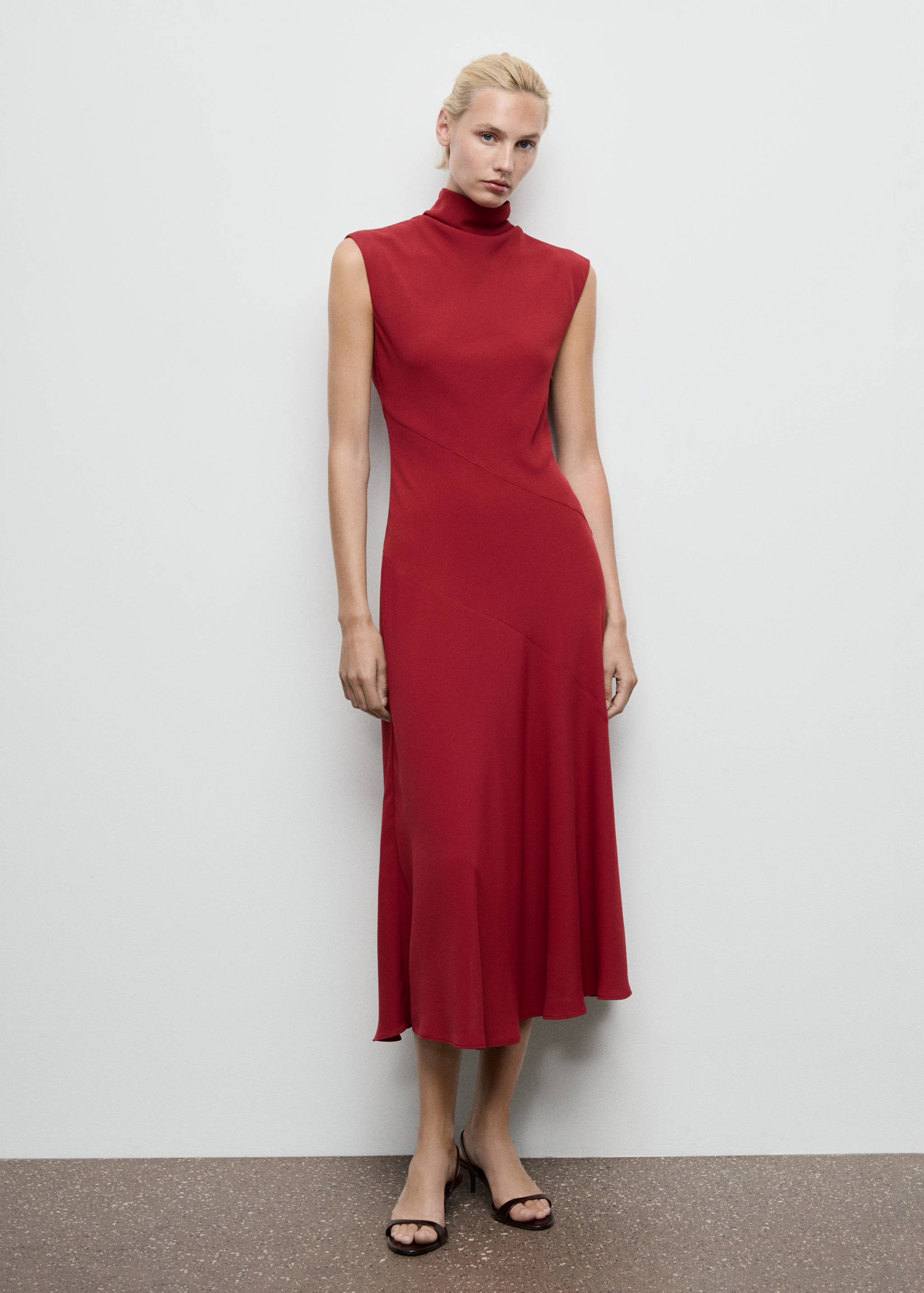 Sleeveless red midi dress with high collar and diagonal seams.