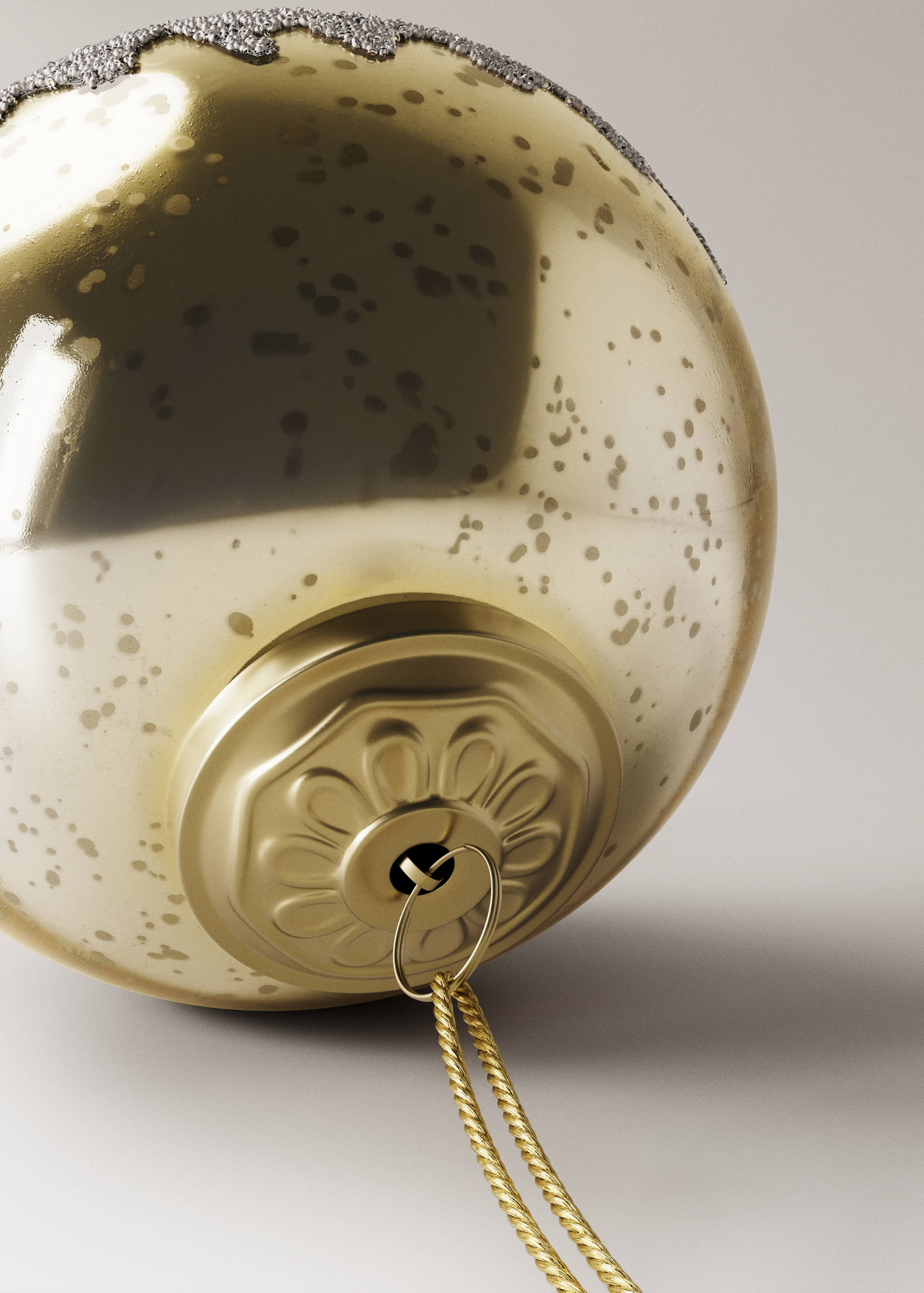 Close-up of a gold Christmas ornament with a glitter band and fluted cap.