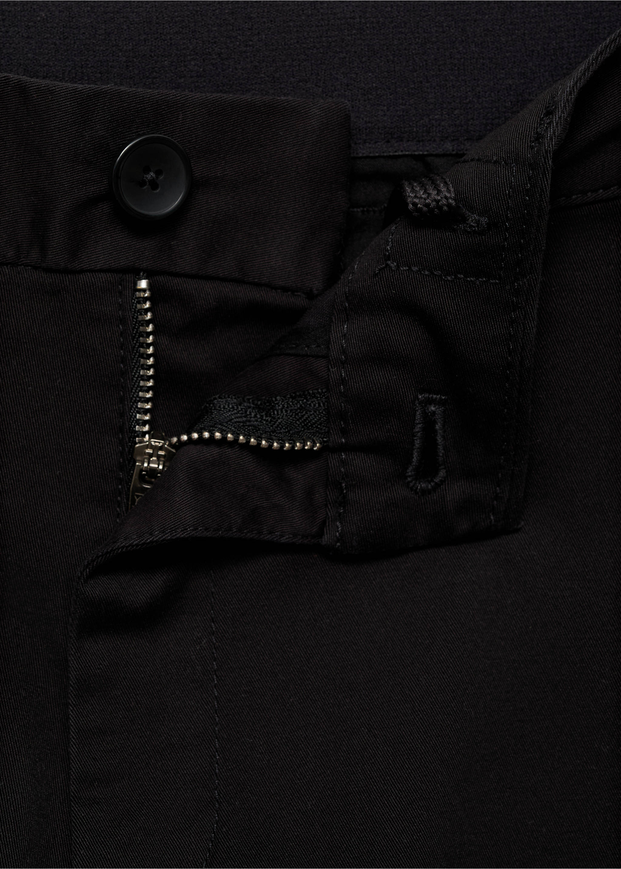 Close-up of black trousers featuring a button closure and zip fly., Black. Ref: 17041144-00.