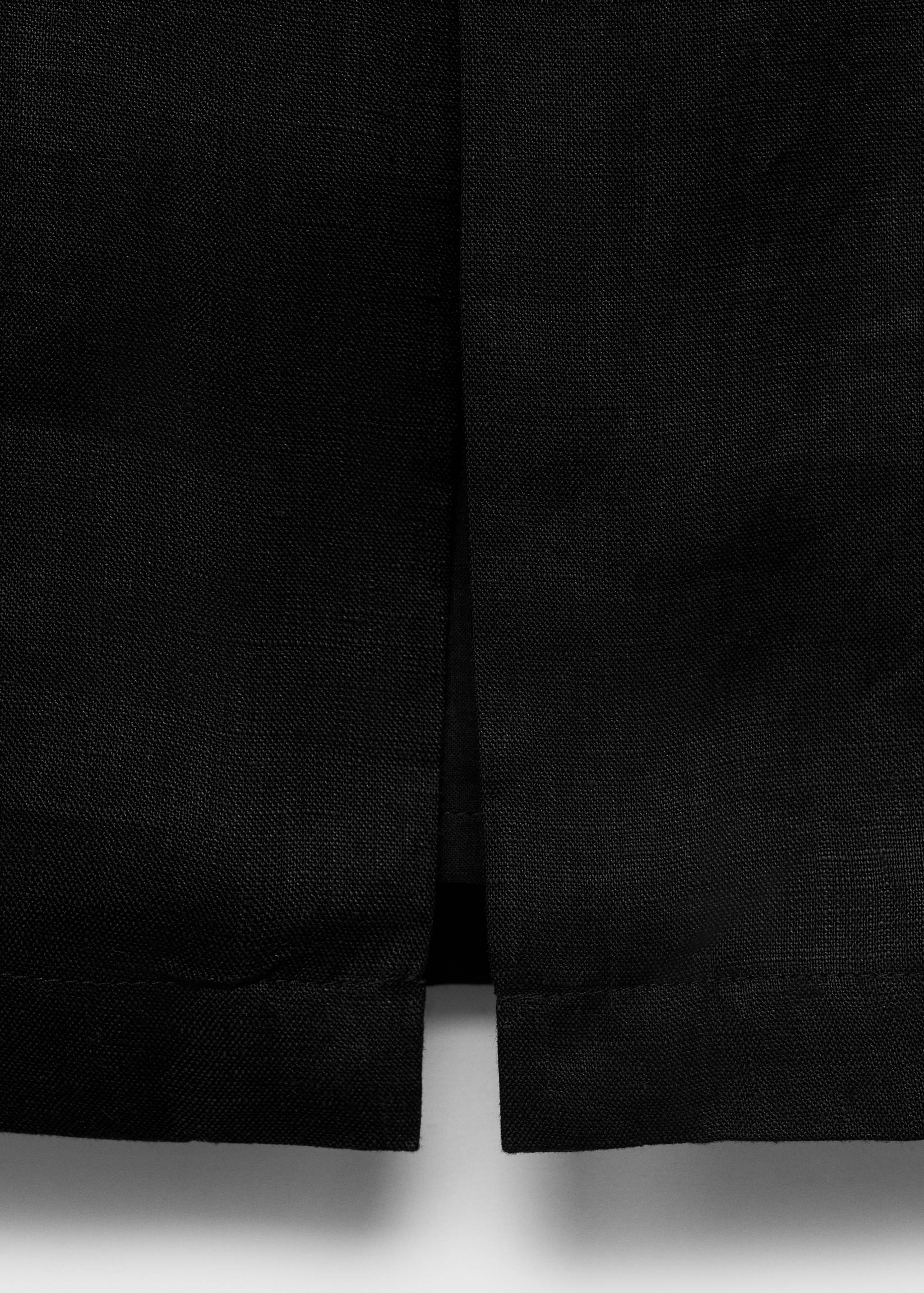 Close-up of a black skirt showing the hem and slit detail.