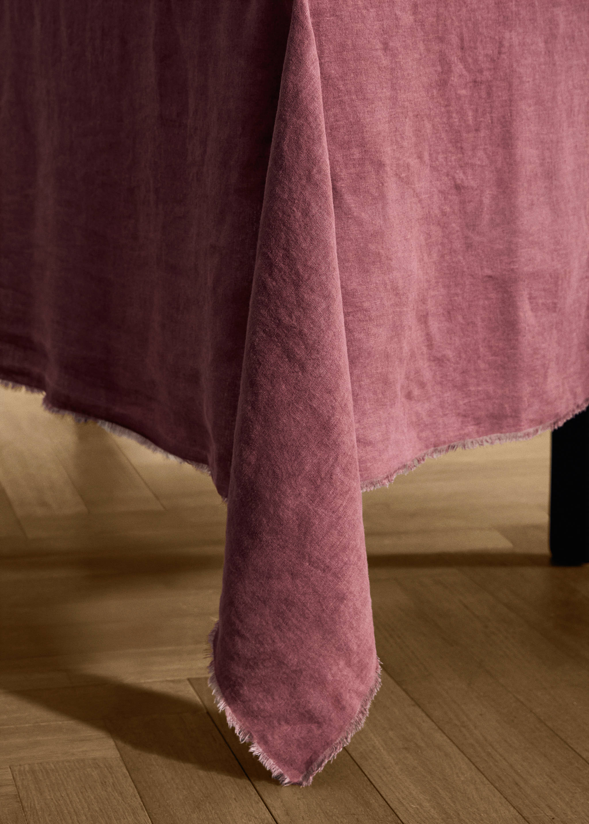 Dusty pink linen tablecloth with a frayed raw hem.