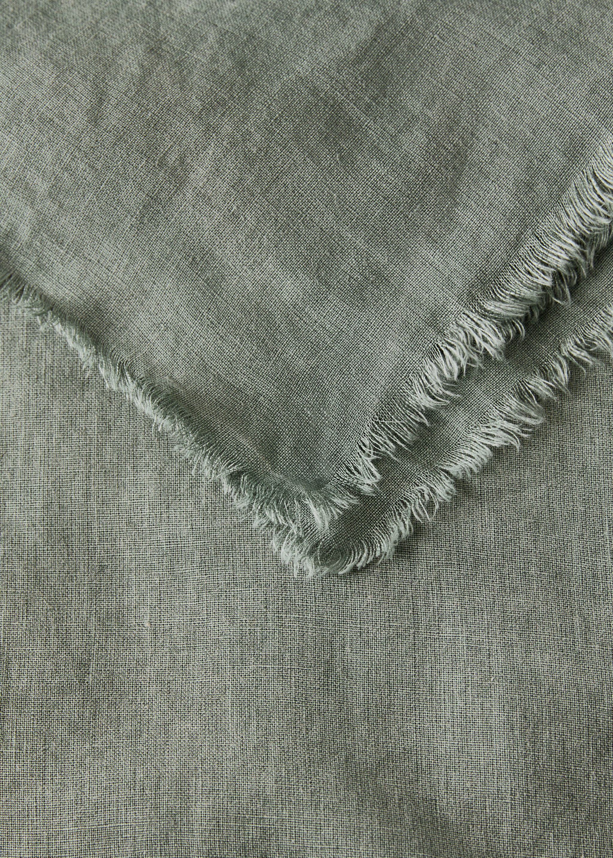 Khaki green tablecloth with a woven texture and frayed edge detail