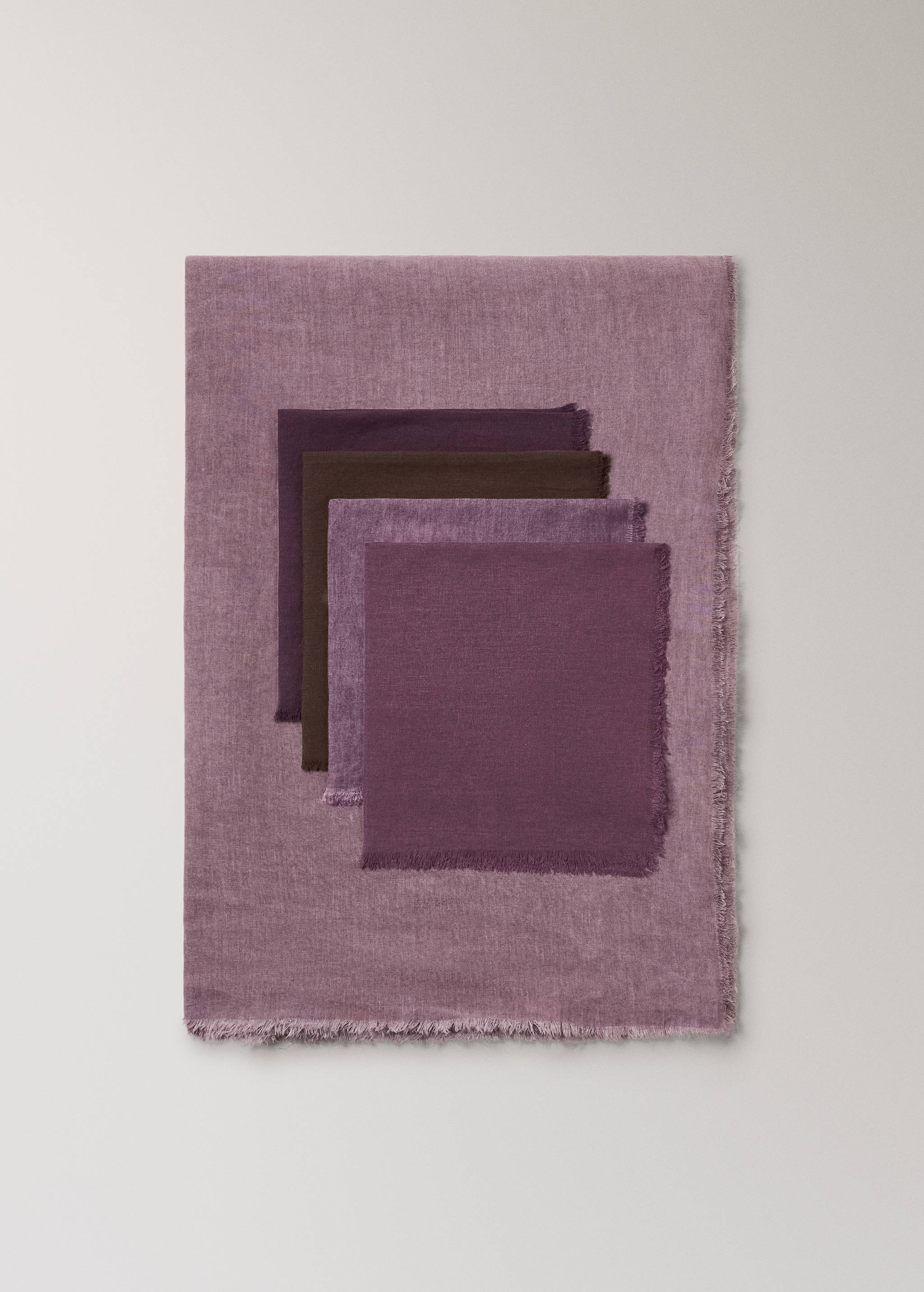 Purple tablecloth with frayed edges, displayed with stacked napkins.
