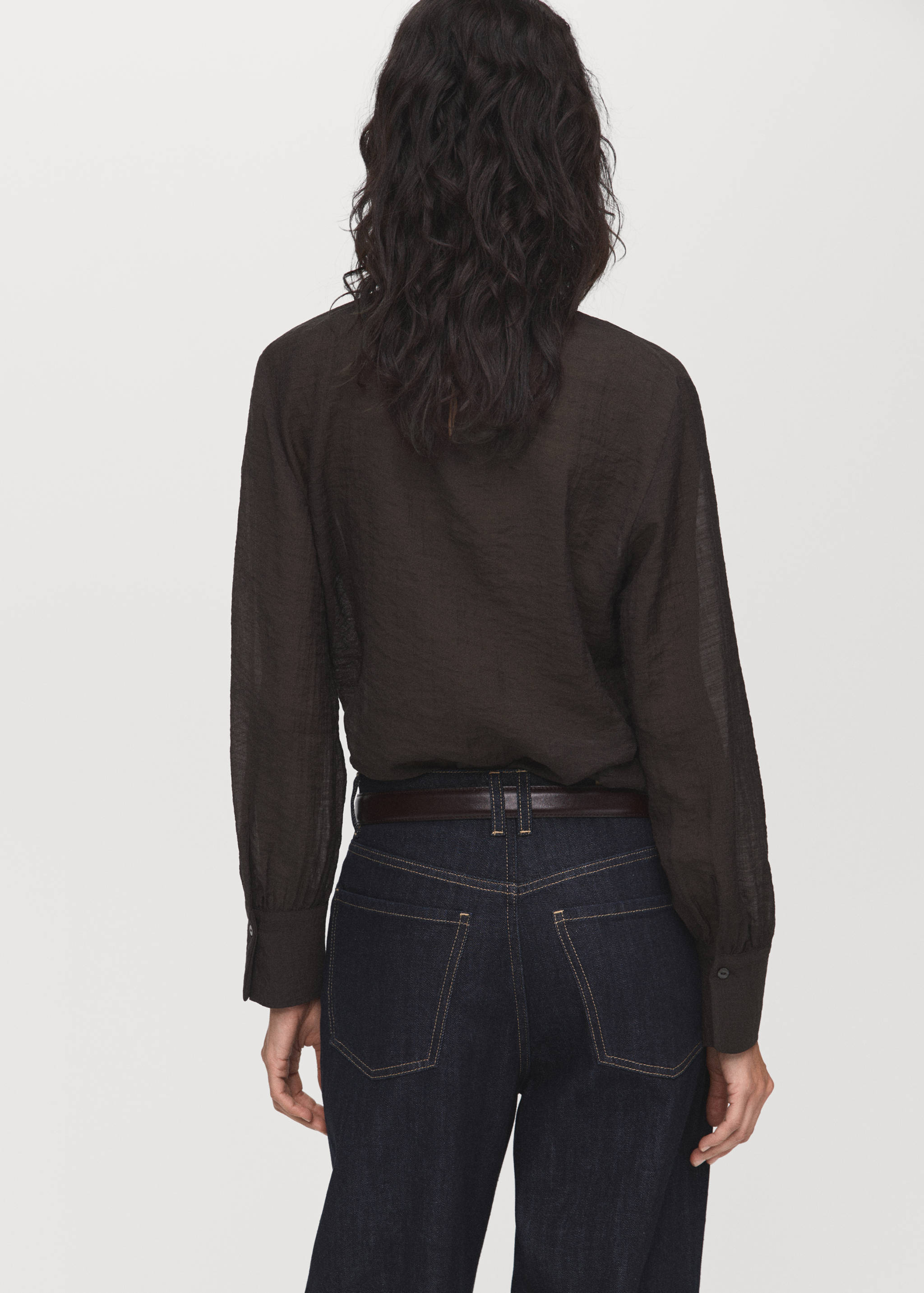 Dark brown long-sleeved blouse, back view, worn tucked into dark blue trousers.