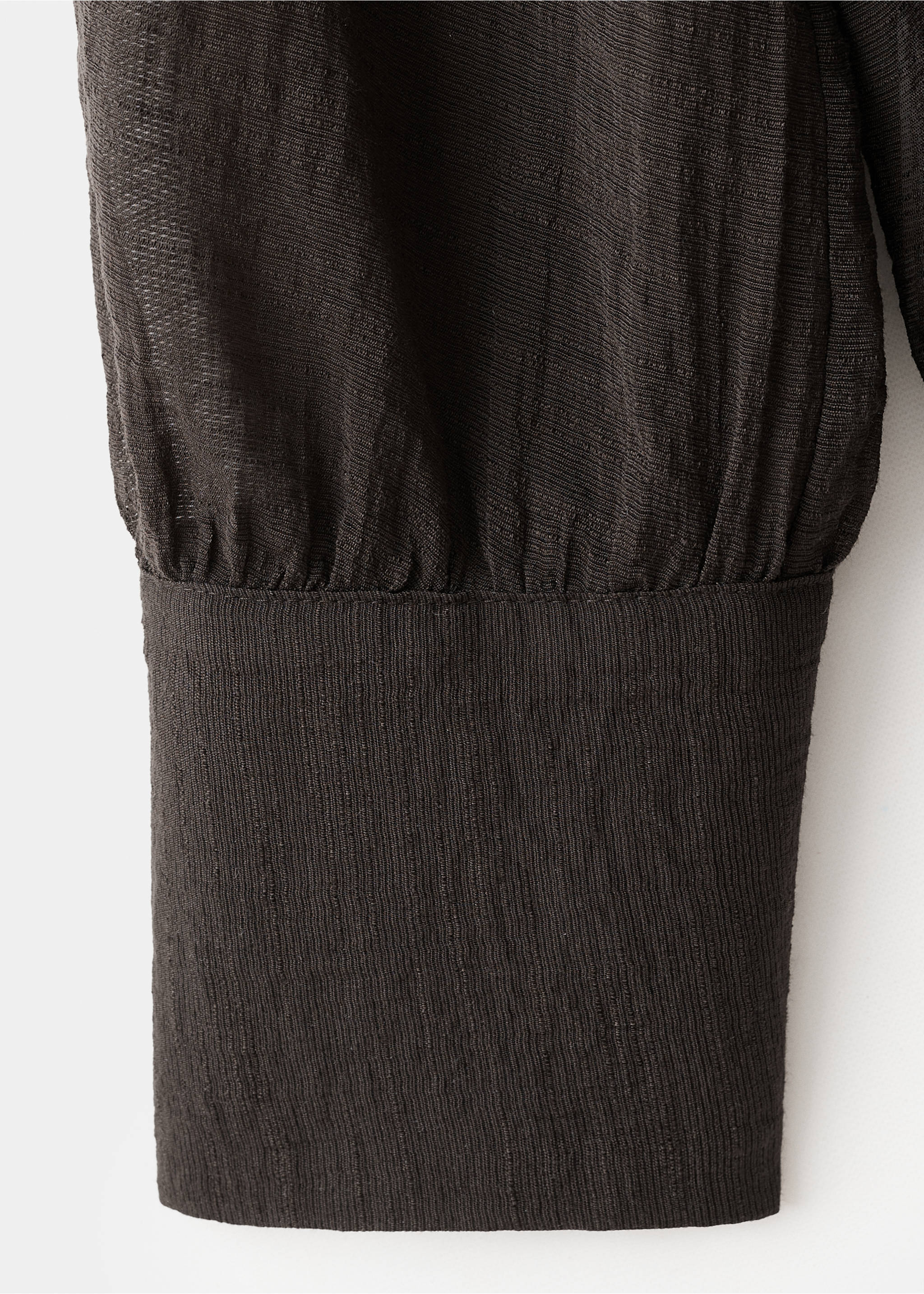 Close-up of a dark brown blouse sleeve with gathered cuff and textured fabric., Chocolate. Ref: 17044138-00.