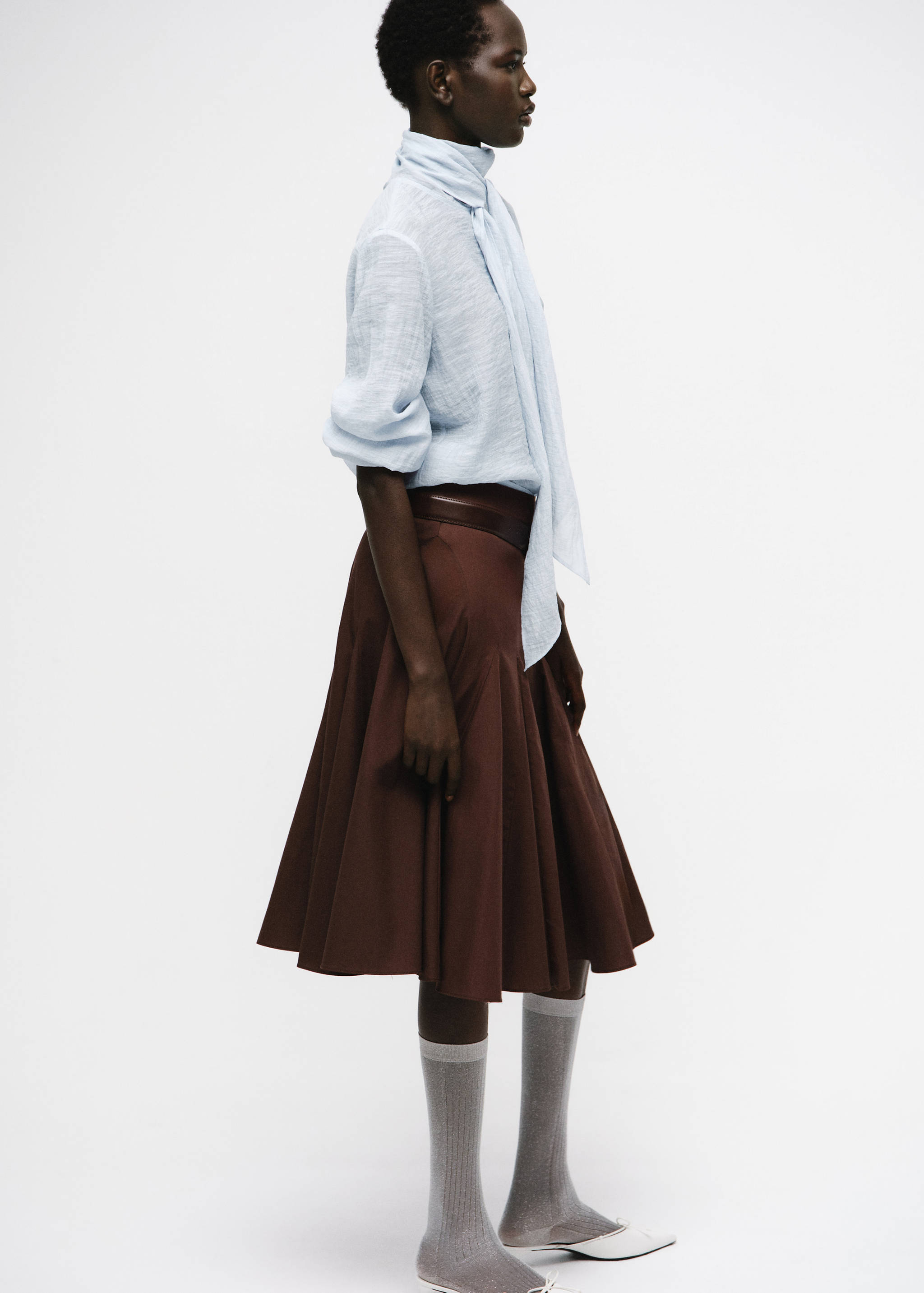 Light blue textured blouse with high neck scarf-tie detail.