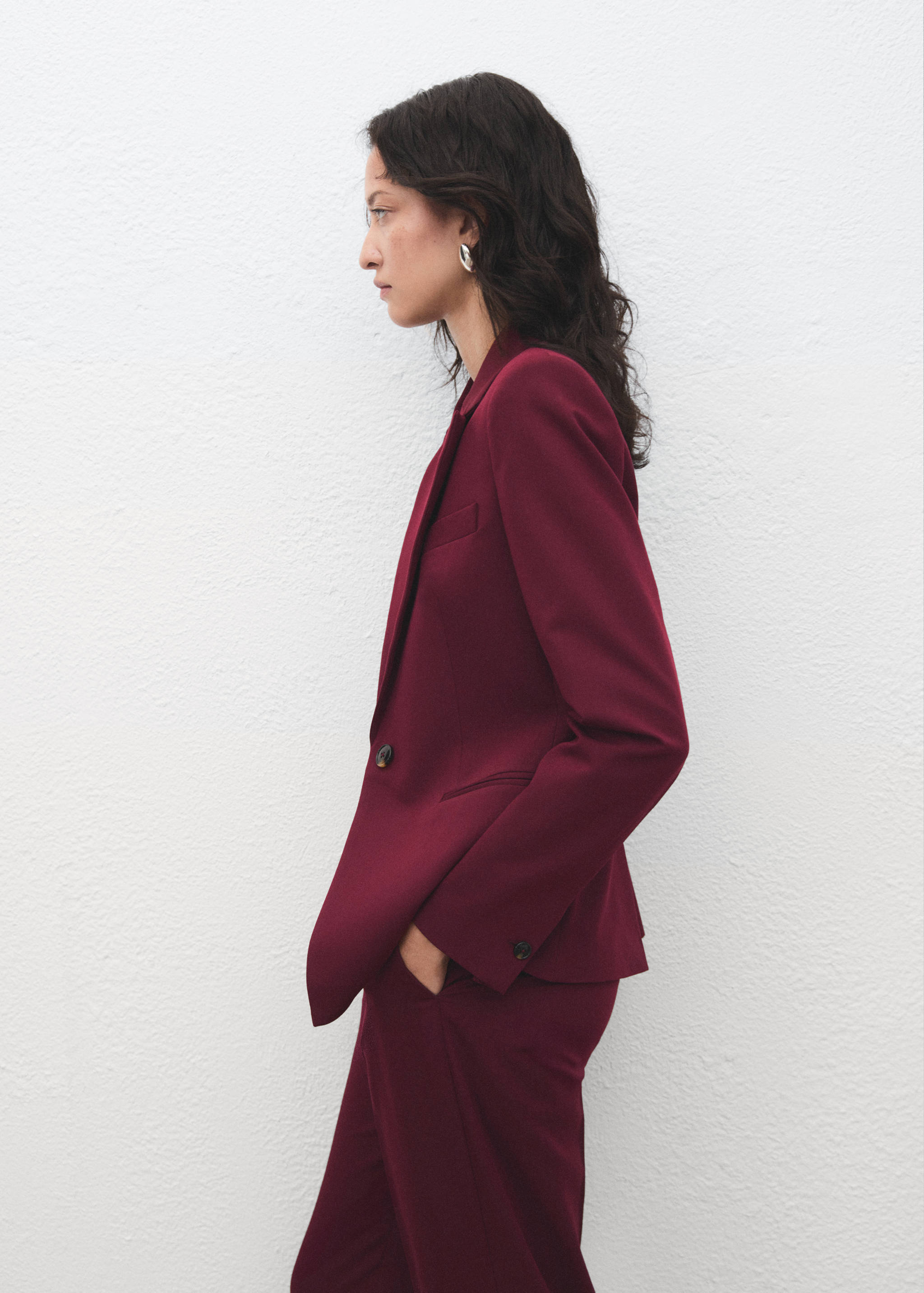 Burgundy tailored blazer with lapels and a single-button closure.