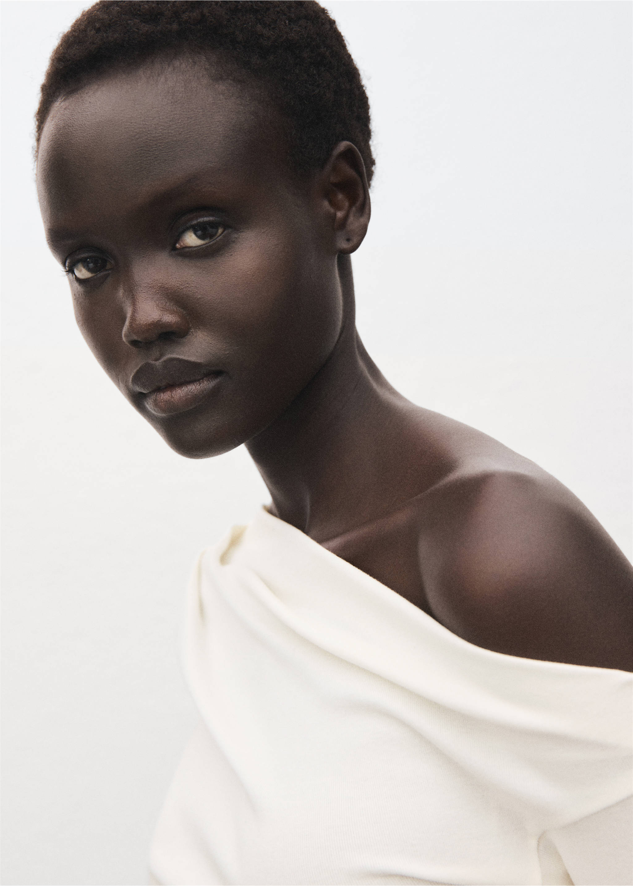 Close-up of a model wearing an off-the-shoulder white t-shirt., Off White. Ref: 17045827-00.