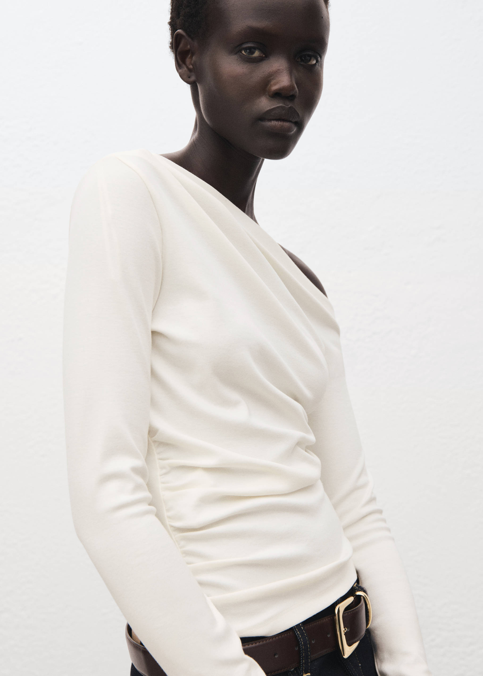 White off-the-shoulder long-sleeve t-shirt with draping.