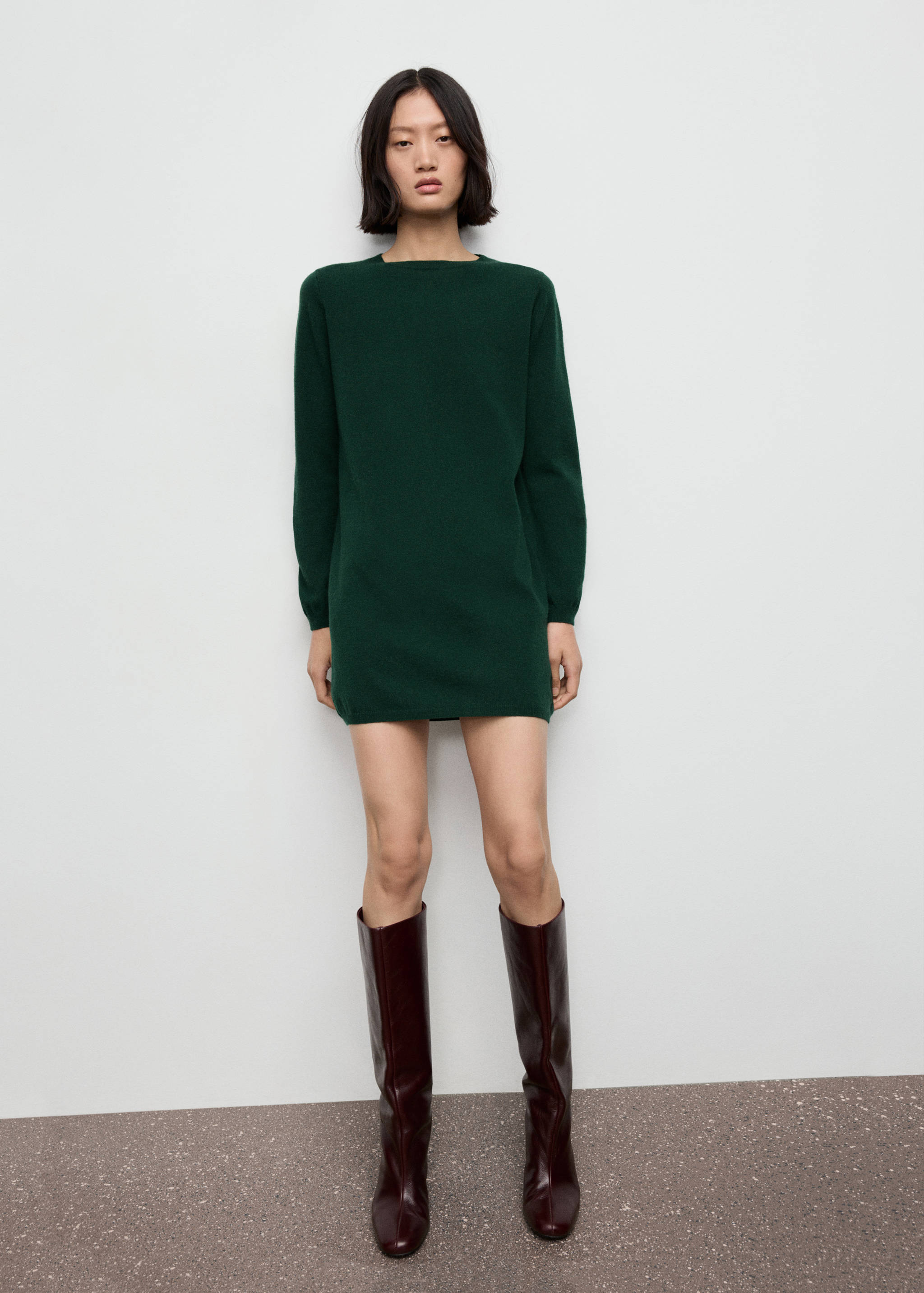 Vestido corto de punto en verde oscuro con manga larga y escote recto.