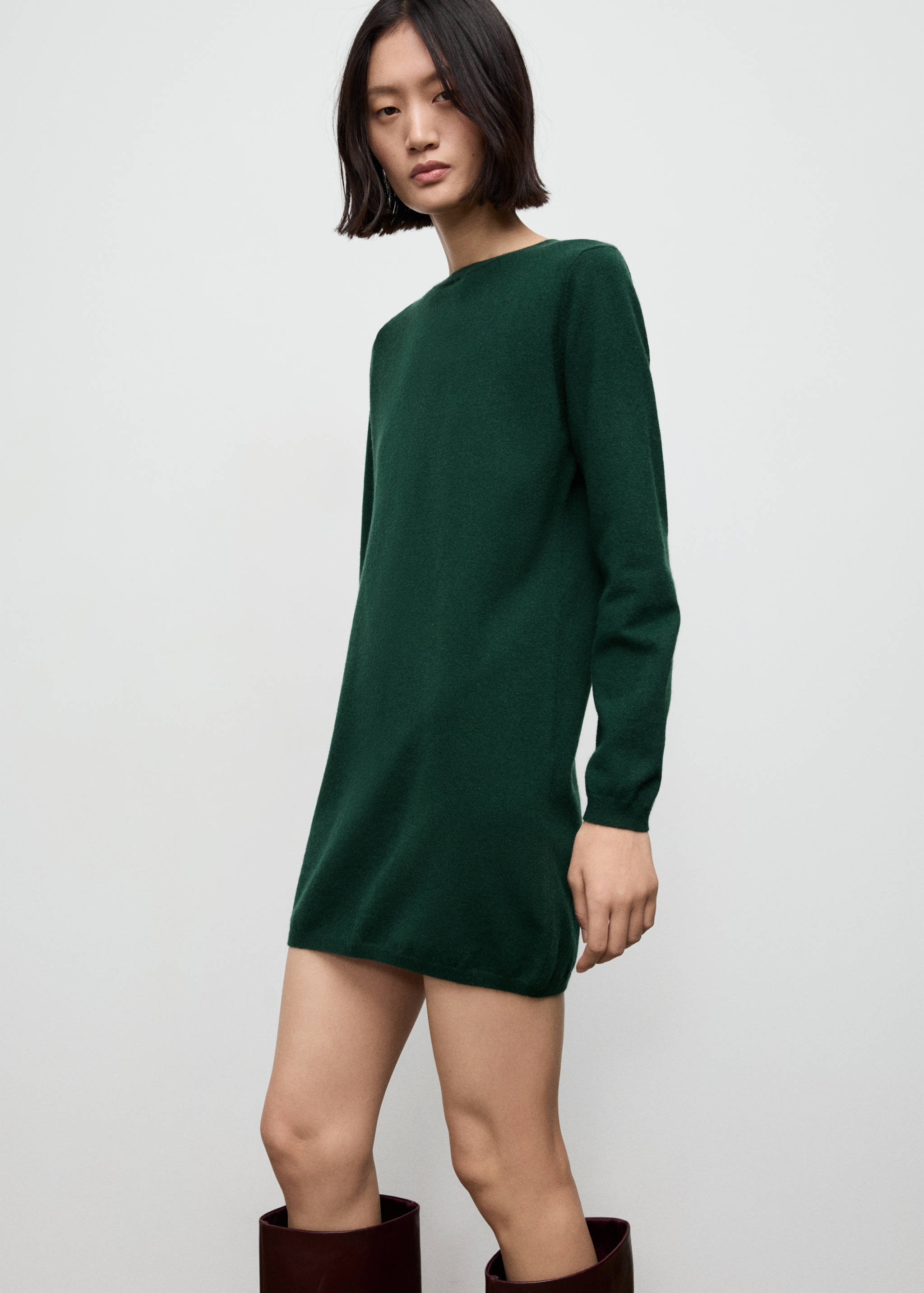 Vestido recto de punto en verde oscuro con cuello redondo y manga larga.