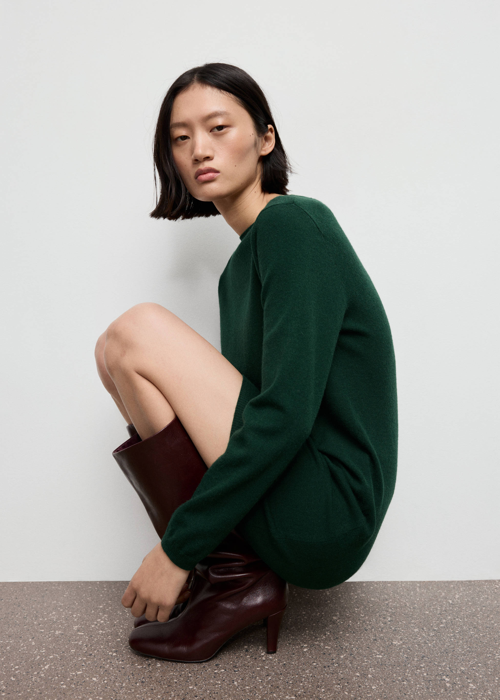Vestido corto de punto en verde oscuro con manga larga y cuello redondo.