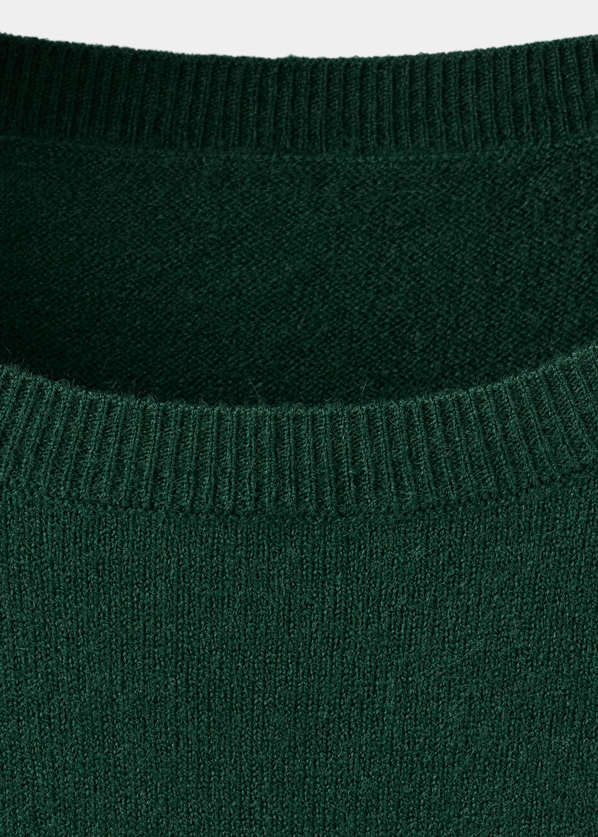 Detalle del escote del vestido de punto verde oscuro