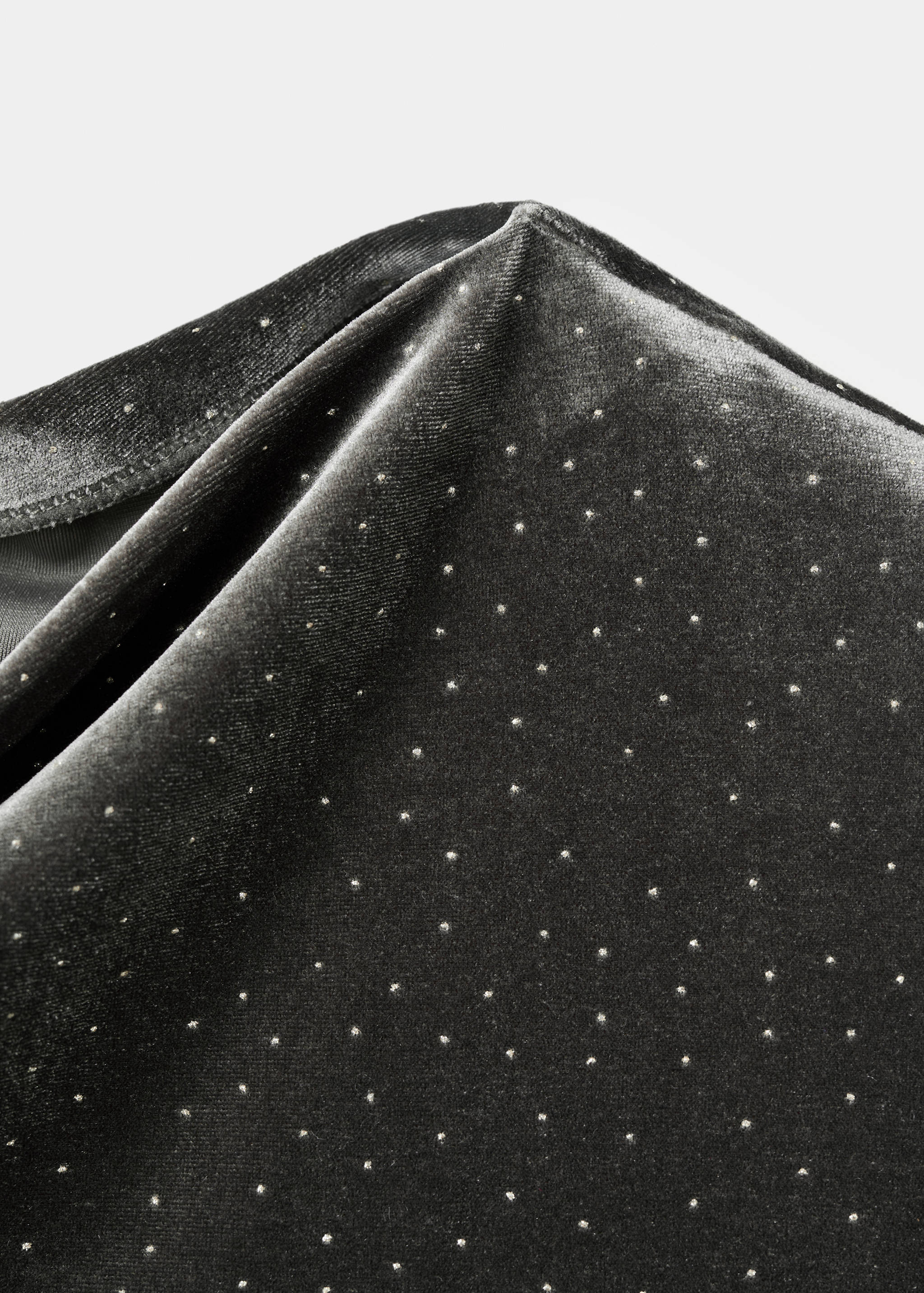 Close-up of a dark grey velvet dress with metallic studs.