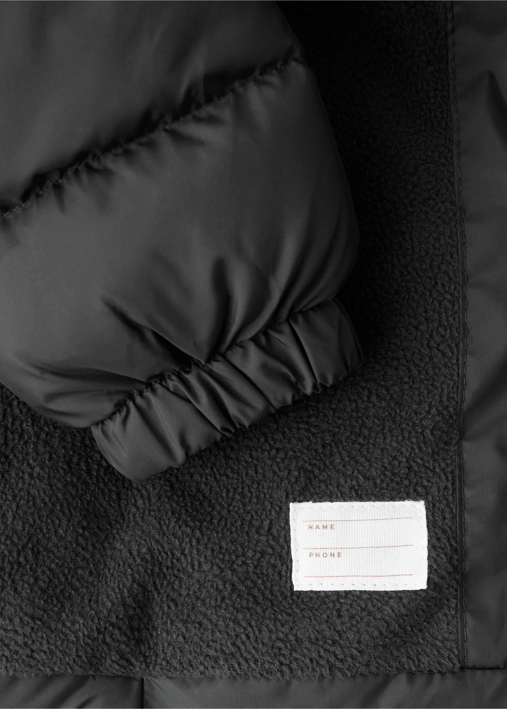 Lange gewatteerde anorak met capuchon - Detail van het artikel 8, Zwart. Ref: 17053791-00.
