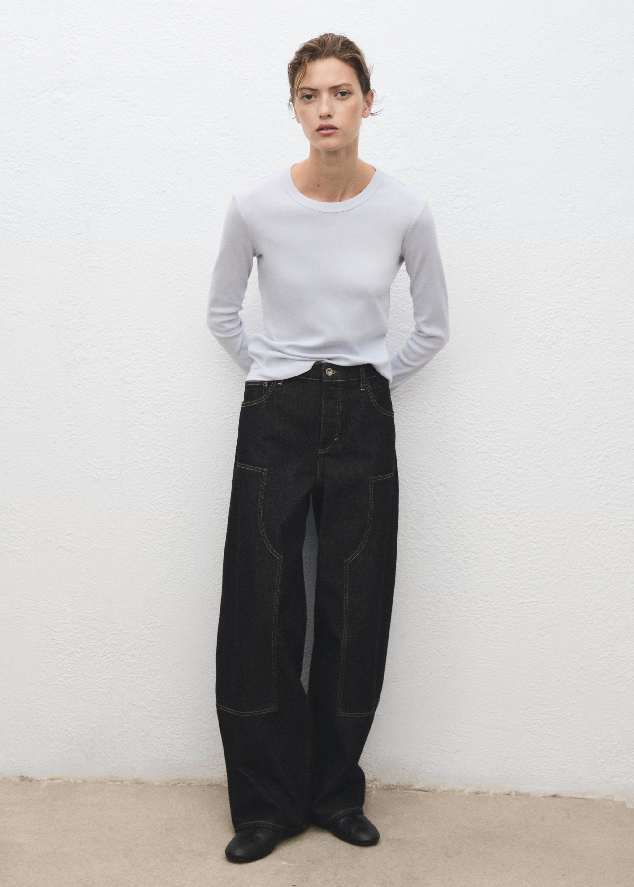 Pale blue long-sleeved t-shirt with a round neckline, worn with dark wide-leg trousers.