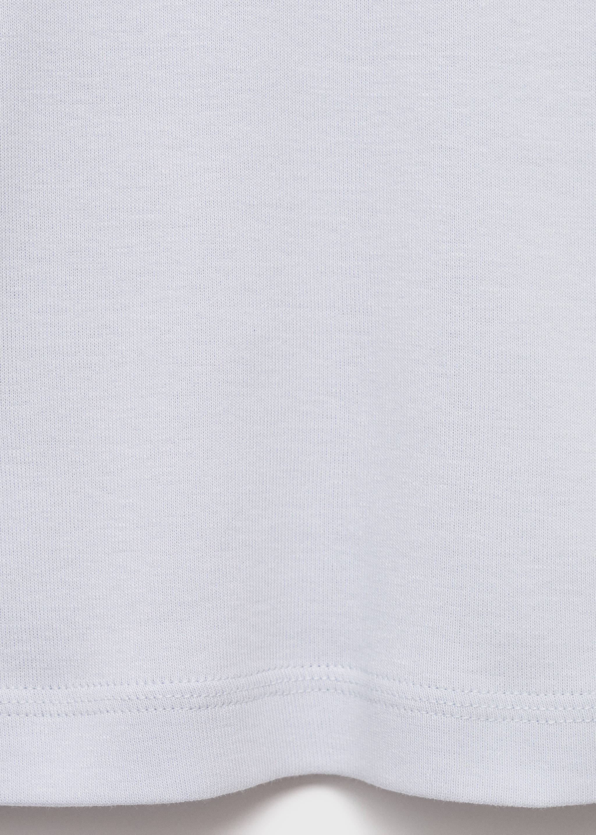 White t-shirt detail showing fabric texture and hem.