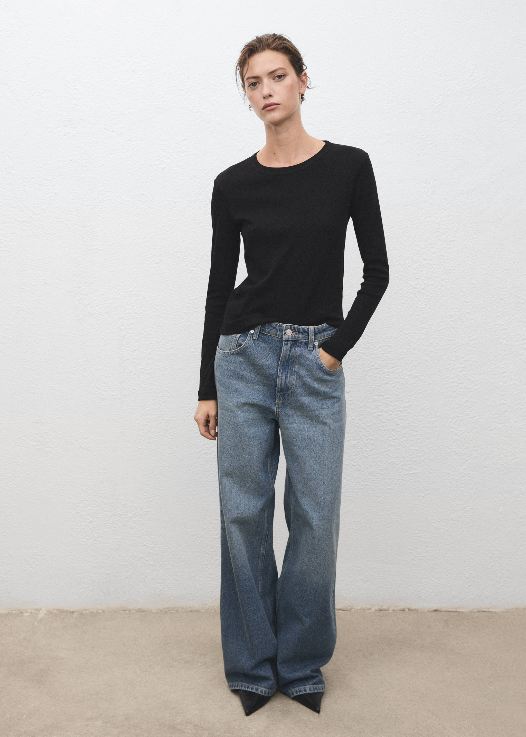 Black long-sleeved ribbed t-shirt worn with blue wide-leg trousers