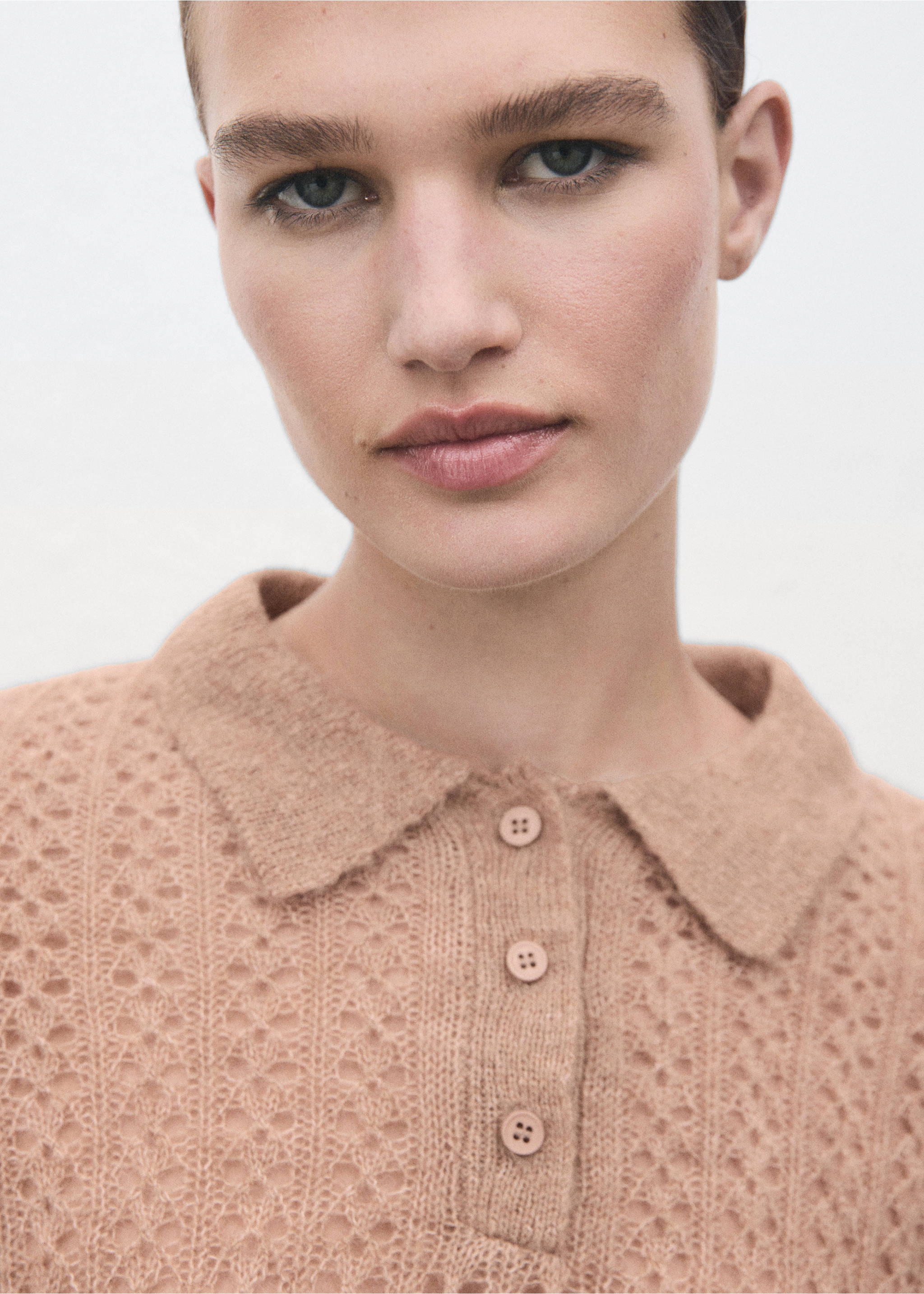 Close-up of a beige knit polo featuring a classic collar and button placket., Medium Brown. Ref: 17055823-00.