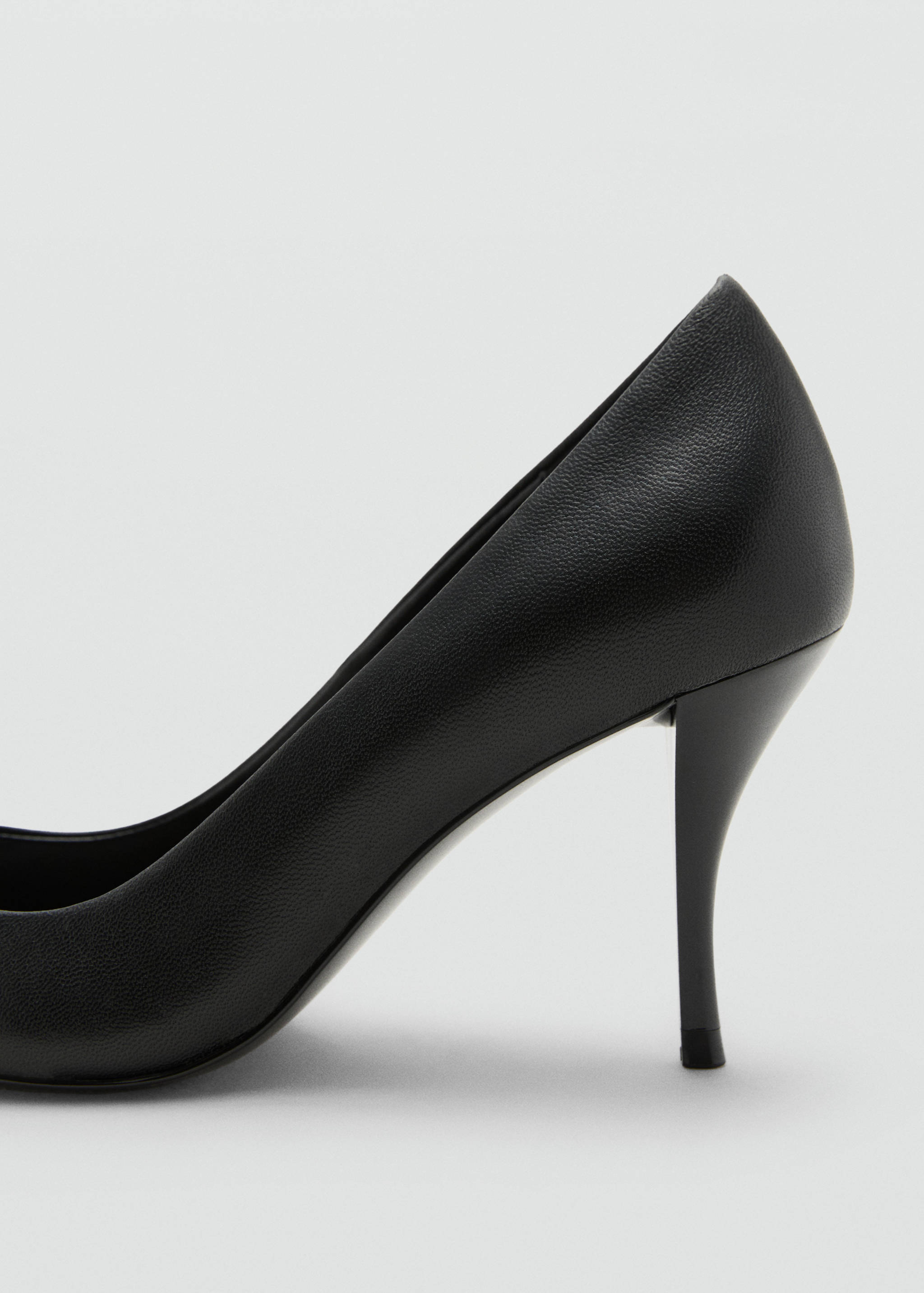 Close-up of a black textured shoe with a stiletto heel.