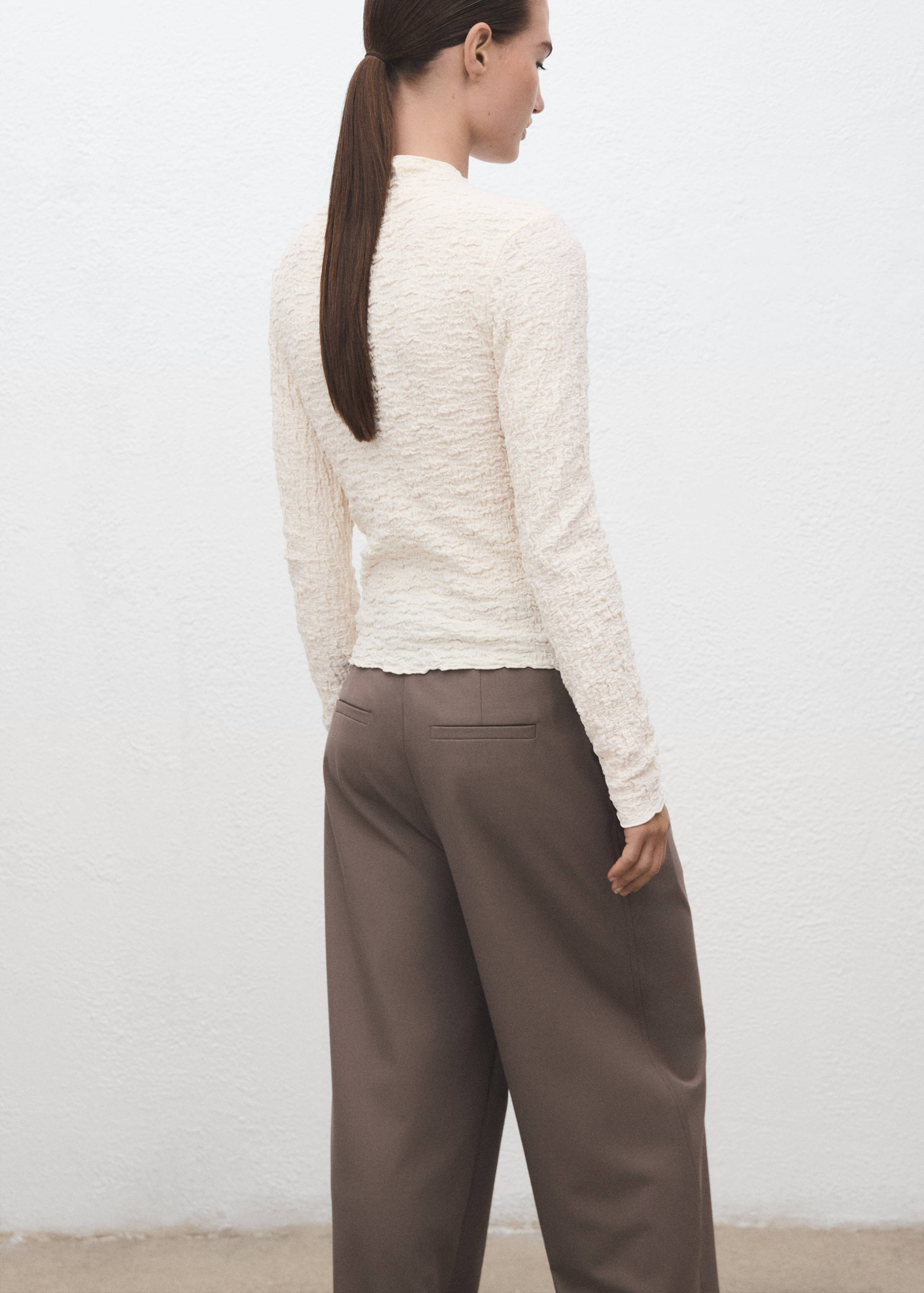 Ecru textured long-sleeved top with a high neck, shown from the back.