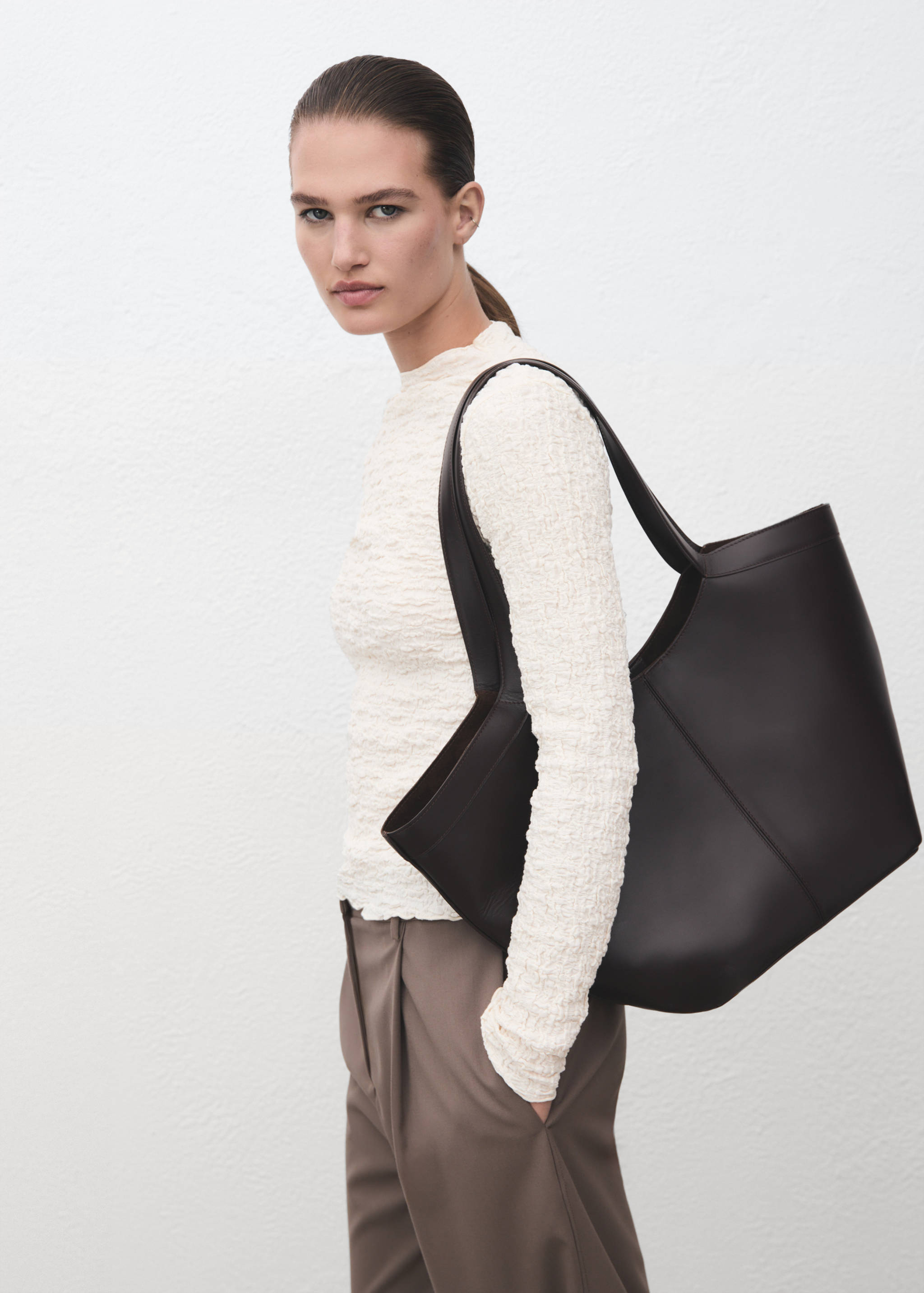 Cream textured long-sleeve top with a high neckline and crinkled finish.