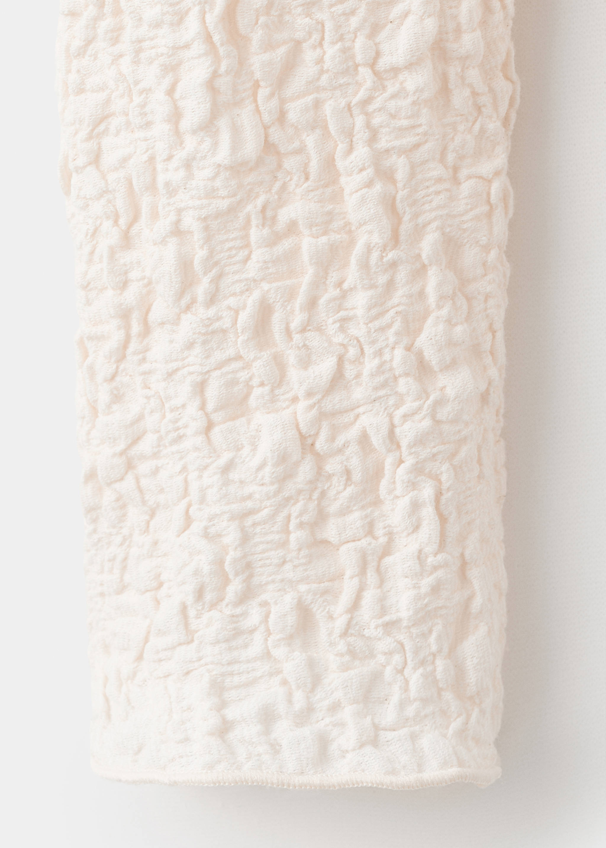Close-up of the textured off-white top fabric.