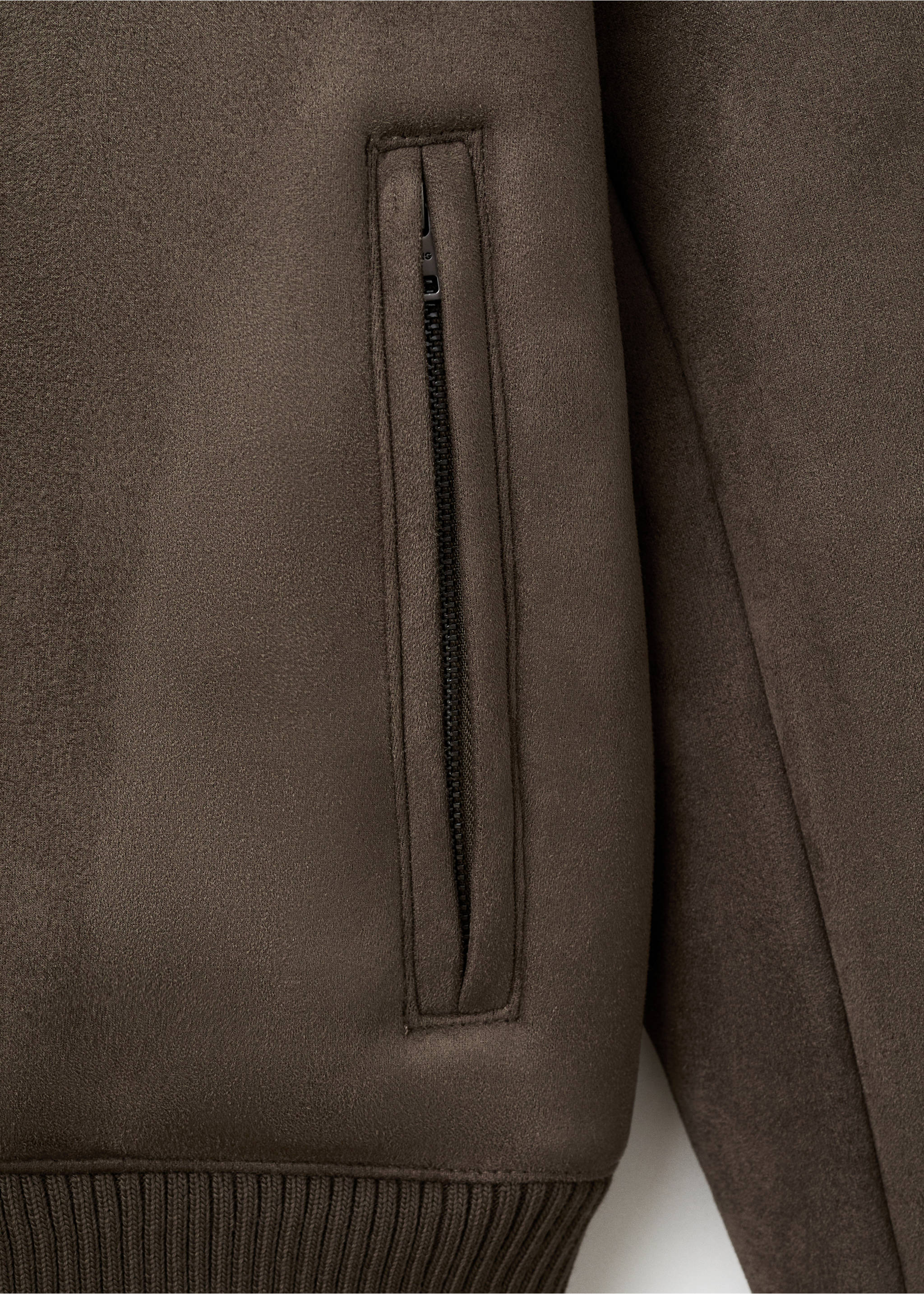 Close-up of a dark brown jacket showing the fabric texture and a zipped pocket., Brown. Ref: 17057884-00.