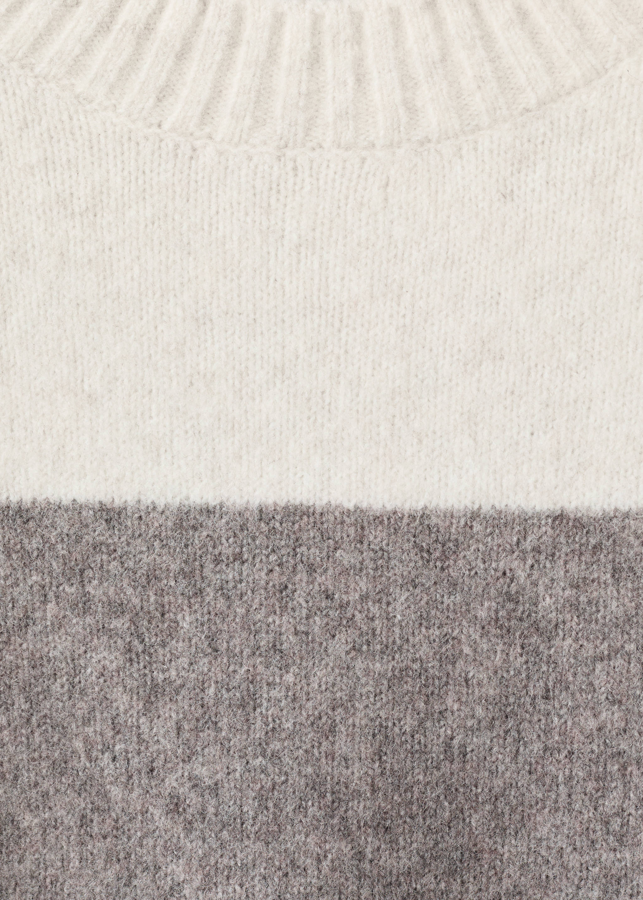 Close-up of an off-white and dark grey colour-block knit jersey.