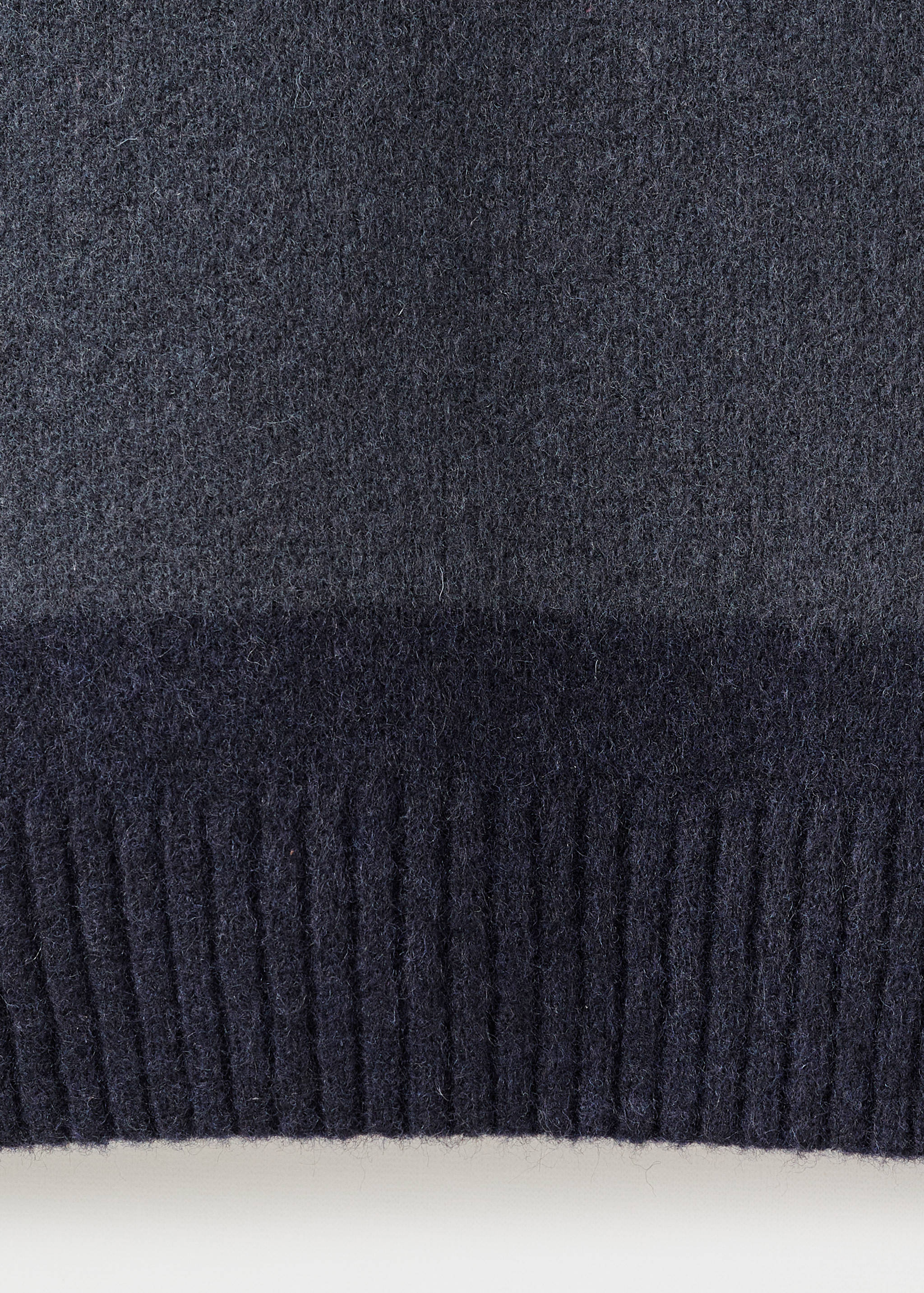 Close-up of a dark grey men's jersey showing the soft knit texture and ribbed hem.