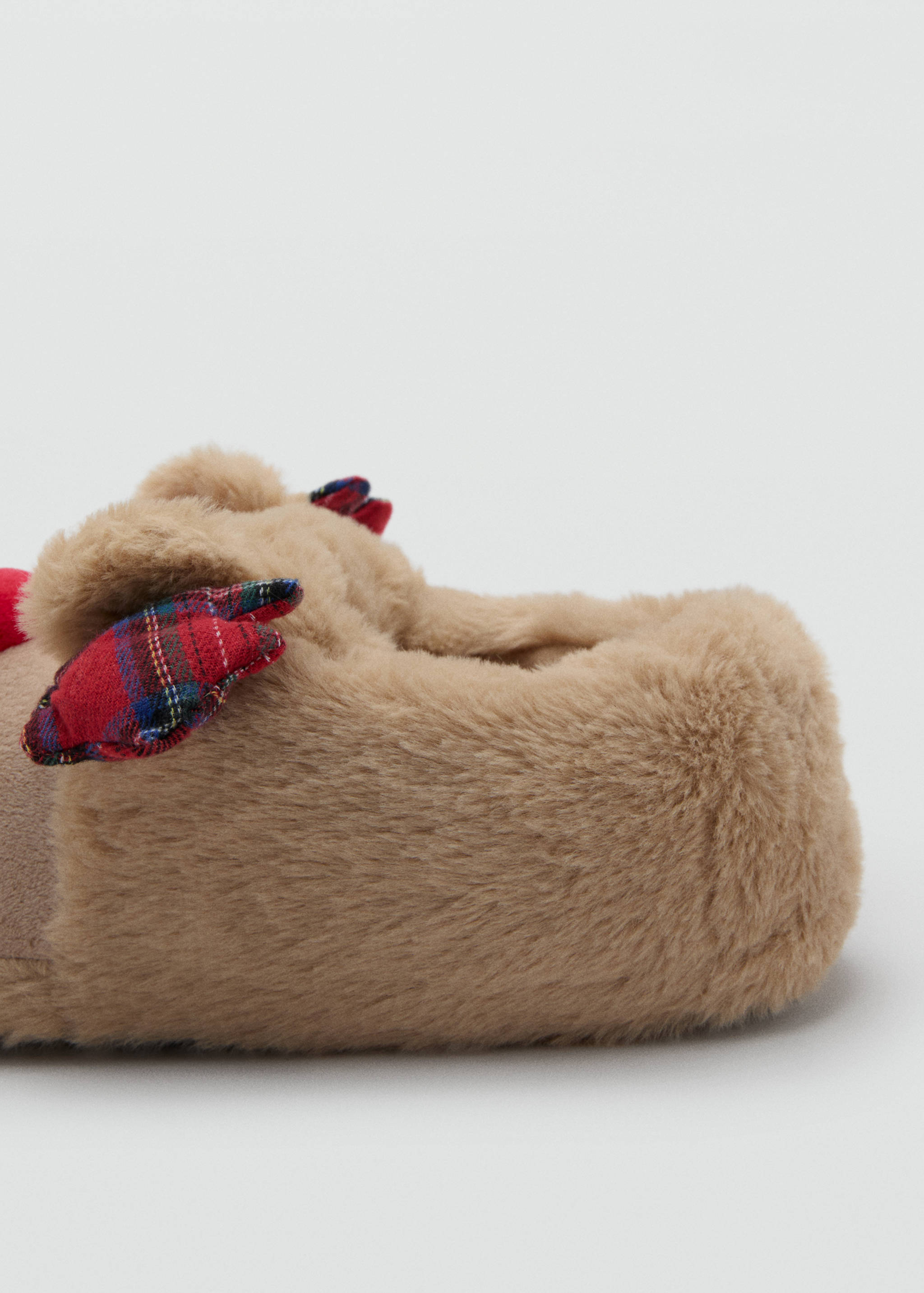 Beige faux-fur house slippers with red and blue plaid detail.