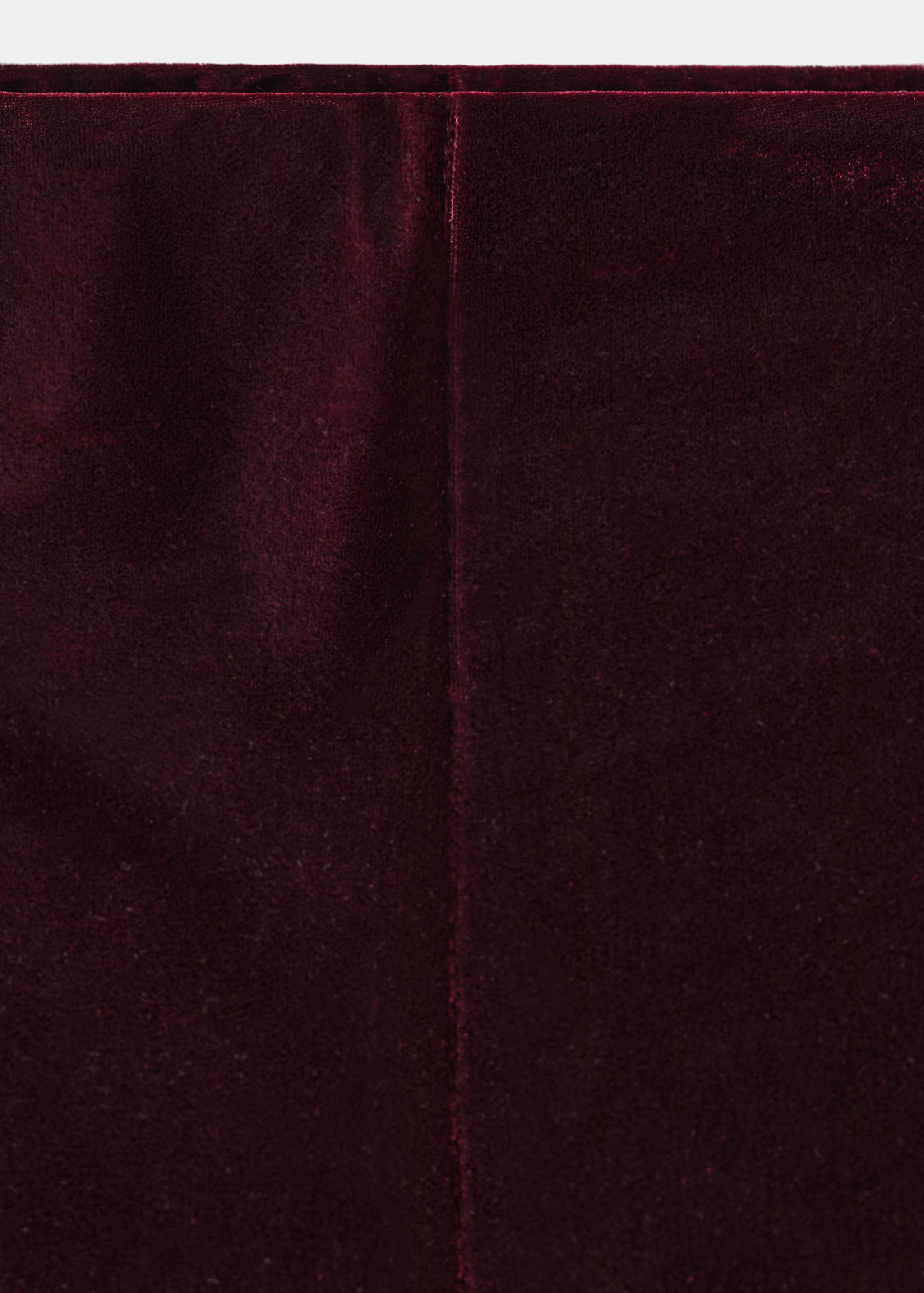 Detalle de los shorts de terciopelo burdeos que muestra su textura suave y su costura.