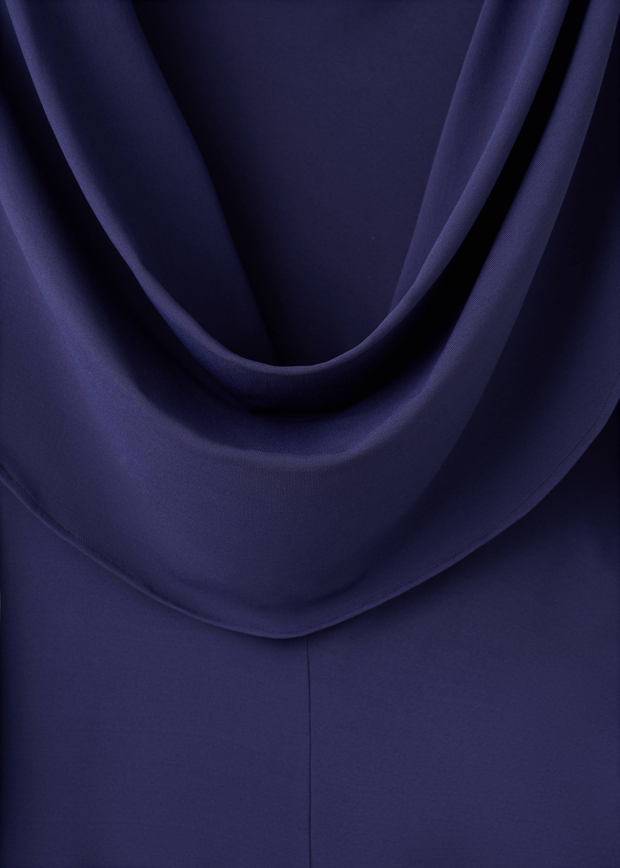 Close-up of a navy blue dress with a draped cowl neckline.