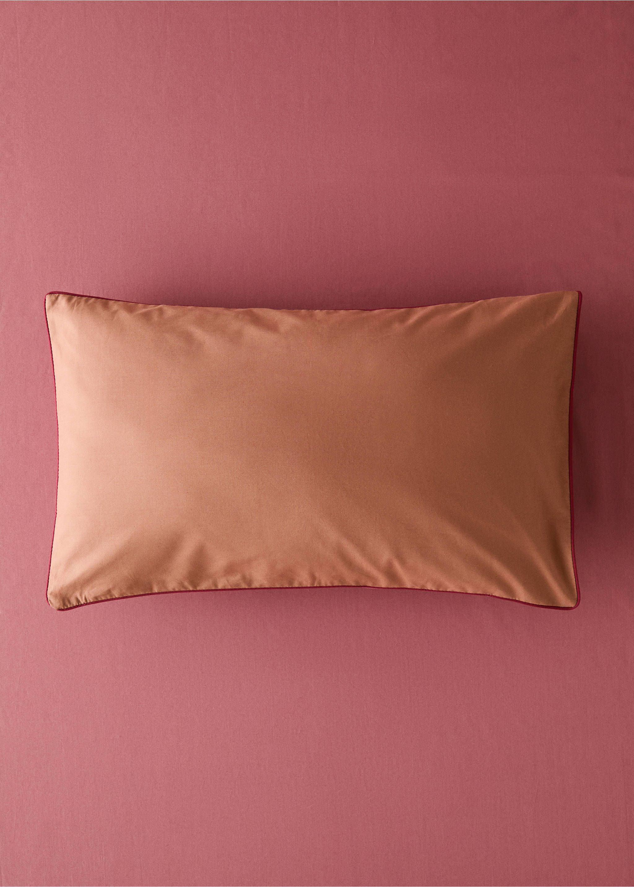Terracotta cot pillowcase with contrasting dark pink piped edges., Pink. Ref: 17061545-00.