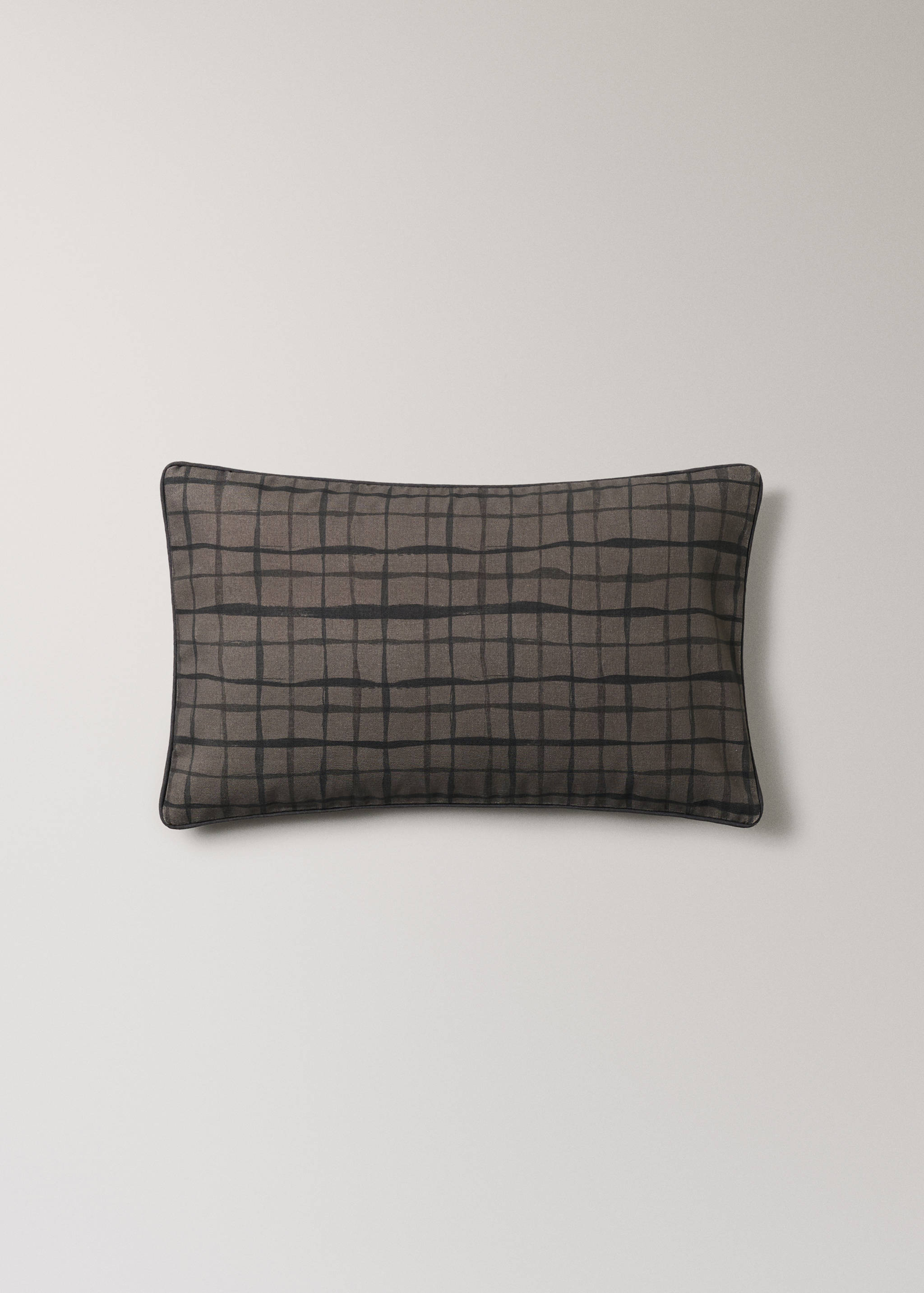 Brown cushion cover with a dark checked pattern and piped edges.