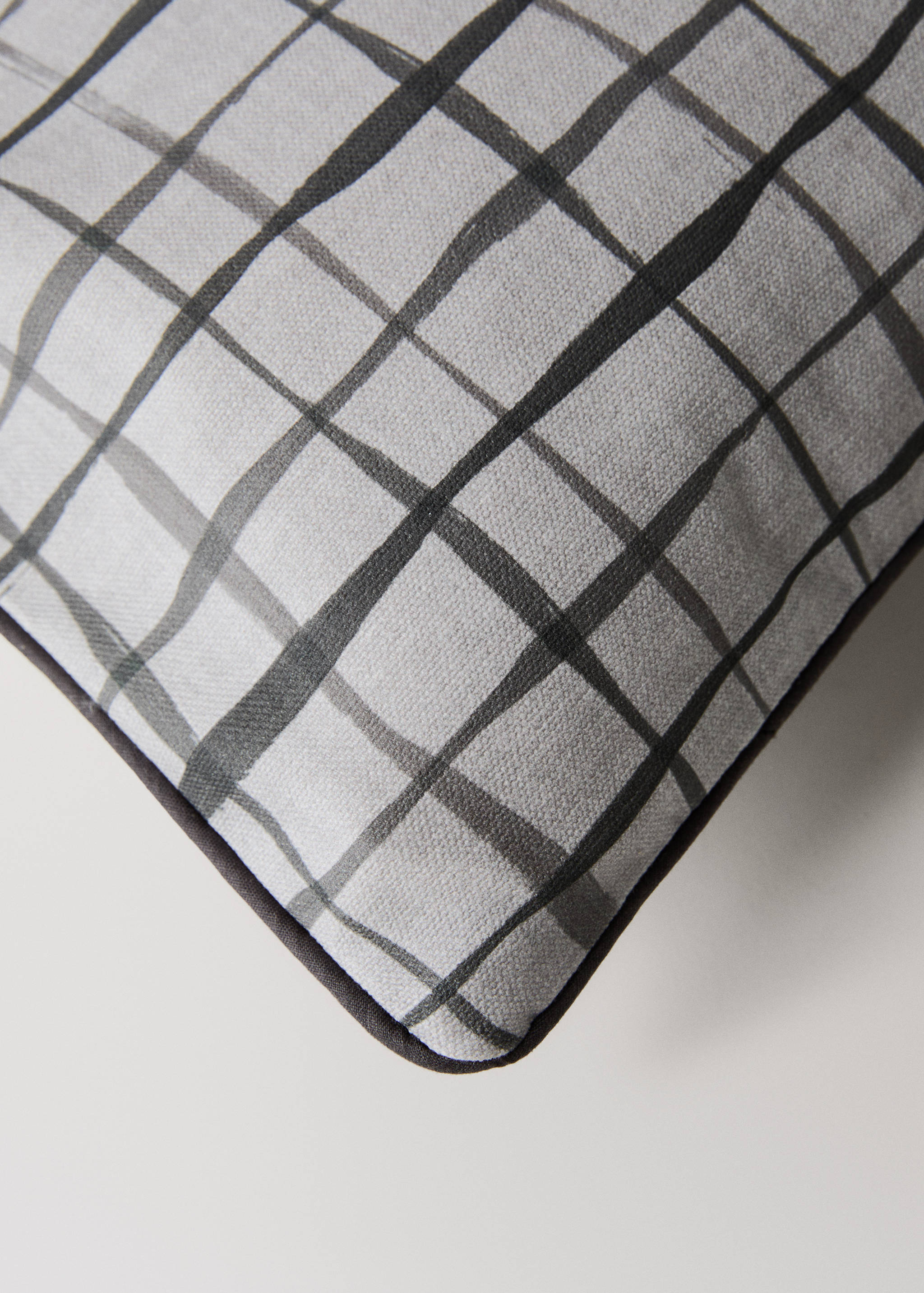 Close-up of a grey checked cushion cover with textured detail.