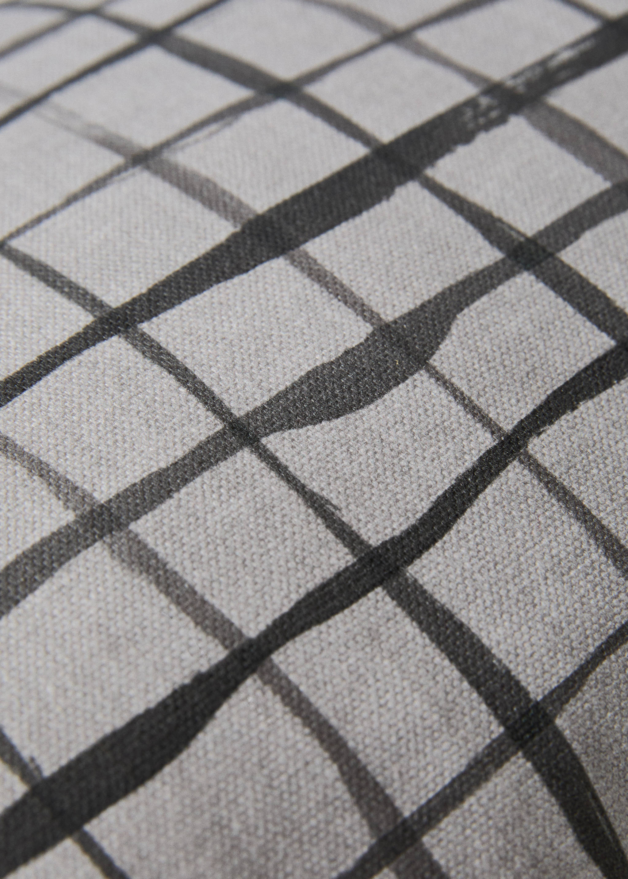 Grey cushion cover with a dark painted check pattern detail.