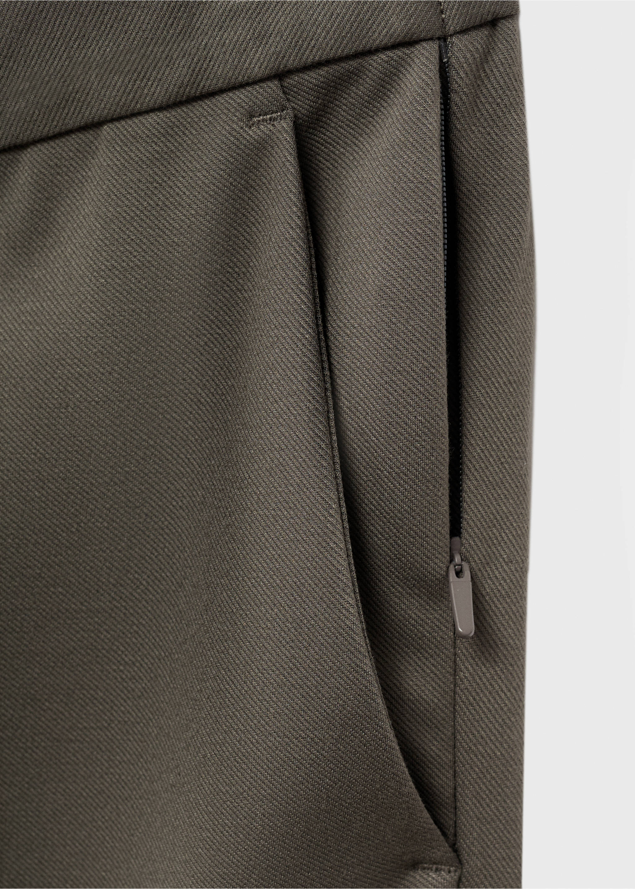 Close-up of dark grey trousers showing fabric texture and zip pocket., Medium Brown. Ref: 17066326-00.