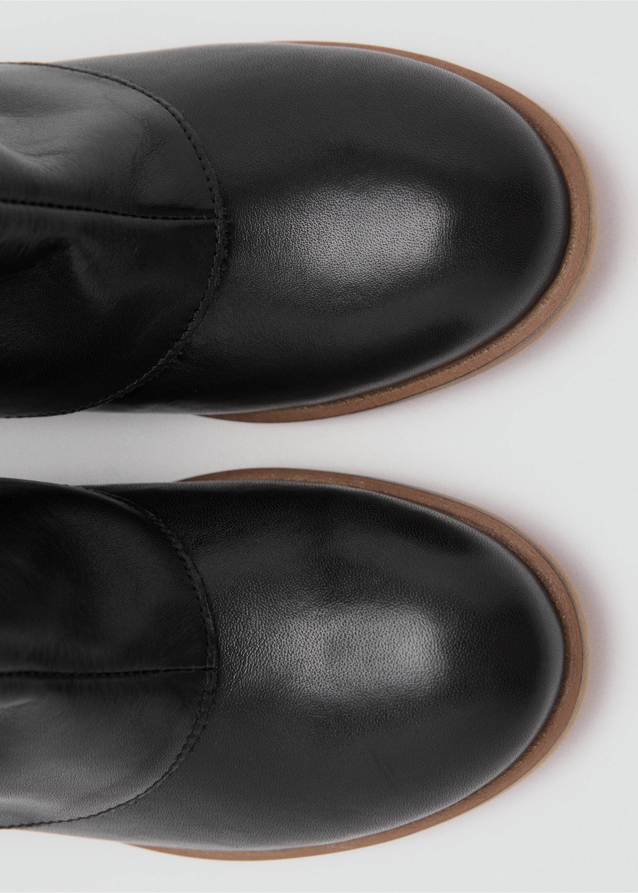 Close-up of black boots with rounded toes and brown soles., Black. Ref: 17066328-00.
