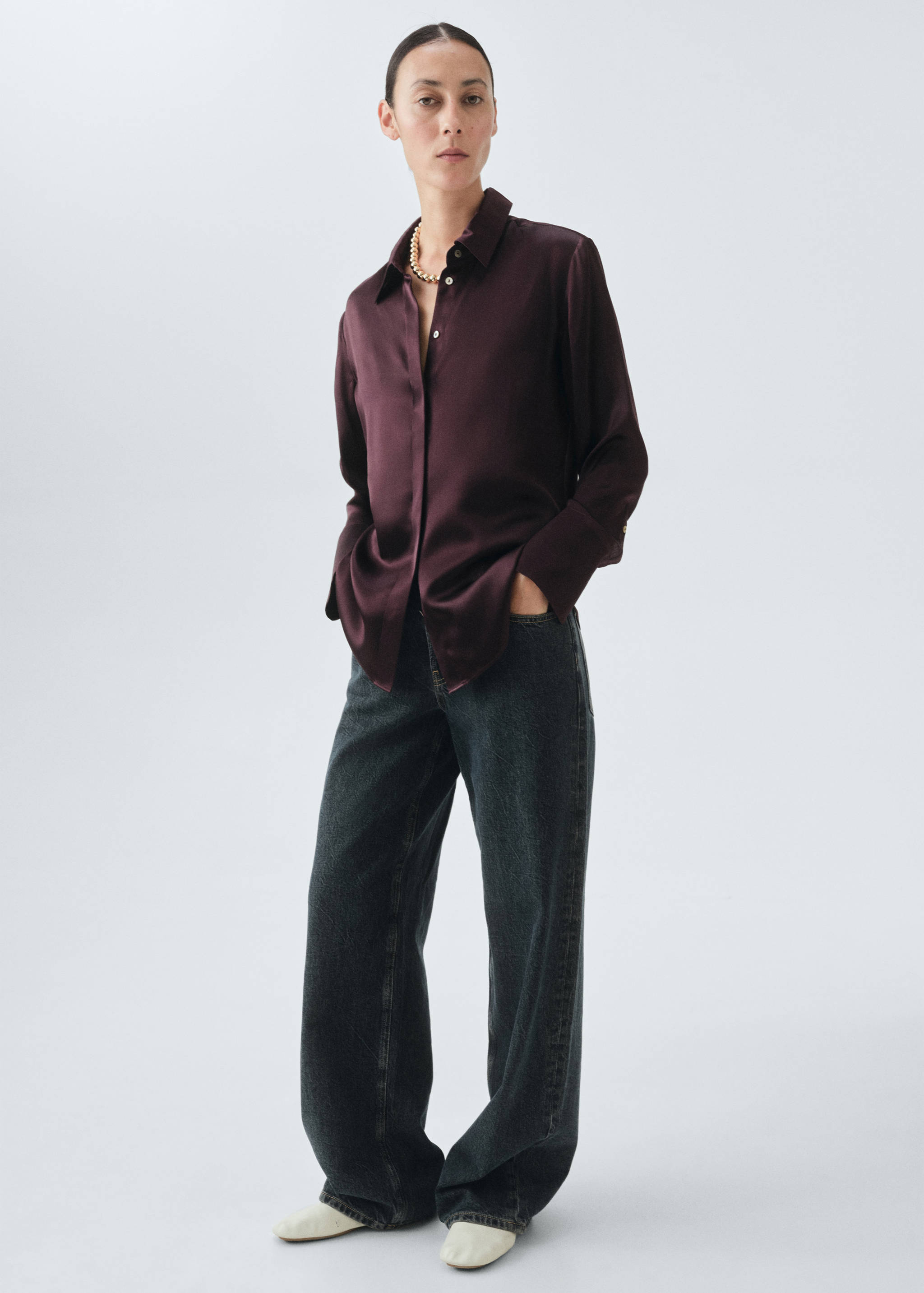 Burgundy satin shirt with a classic collar and long sleeves, styled with dark wide-leg jeans.
