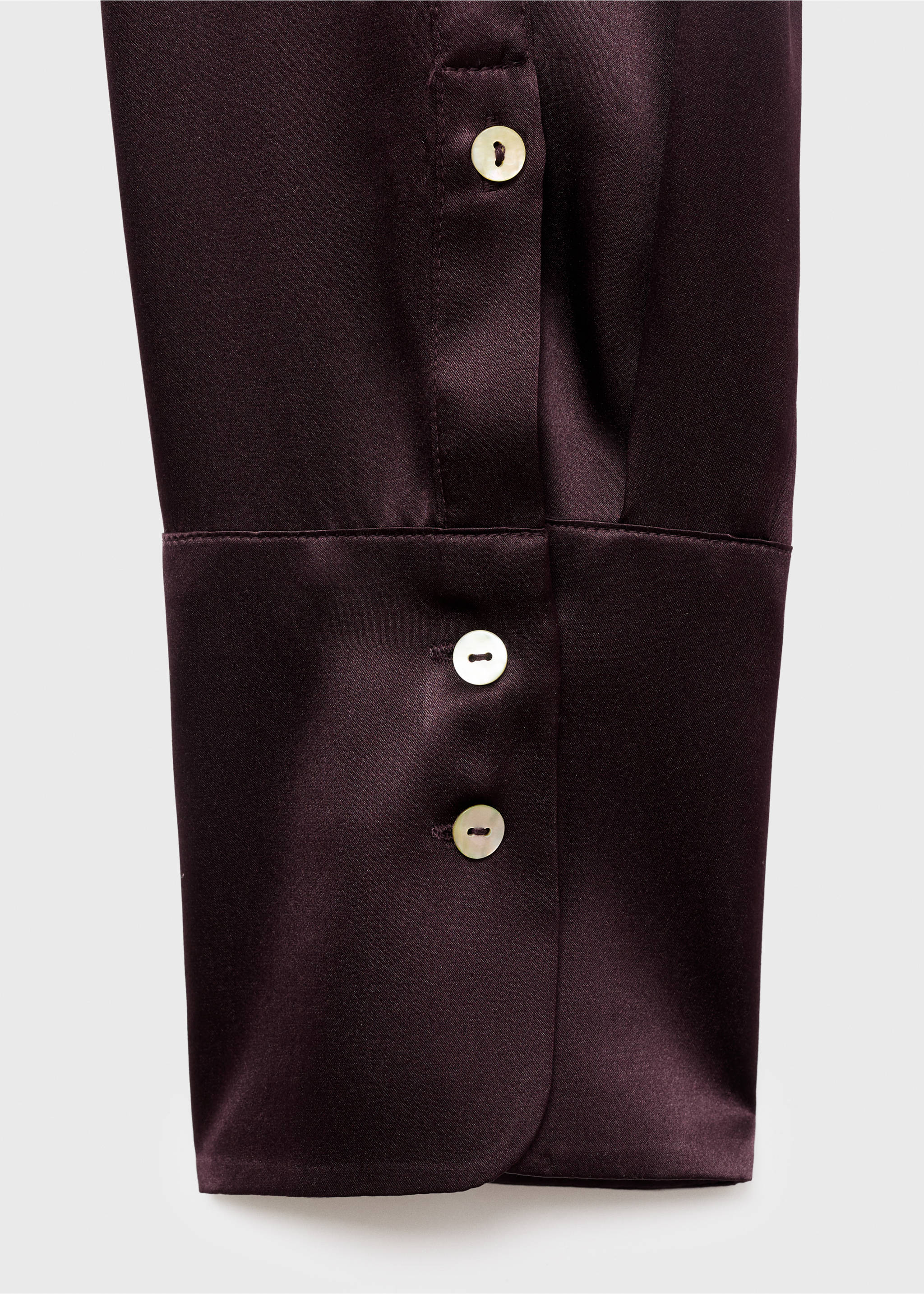 Close-up of a dark plum satin shirt cuff with two pearlescent buttons., Medium Brown. Ref: 17066350-00.