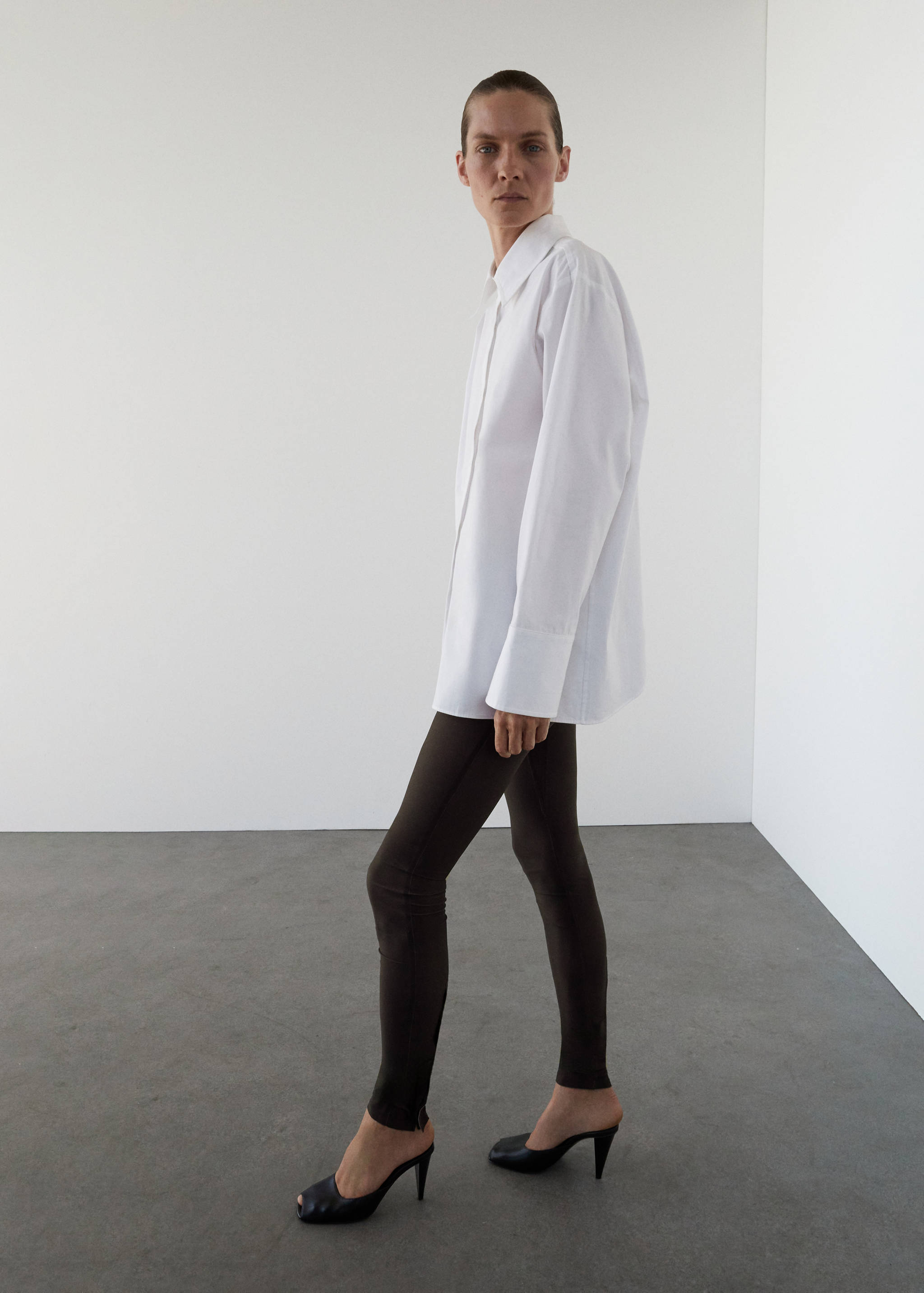 Dark brown fitted leggings worn with an oversized white shirt.