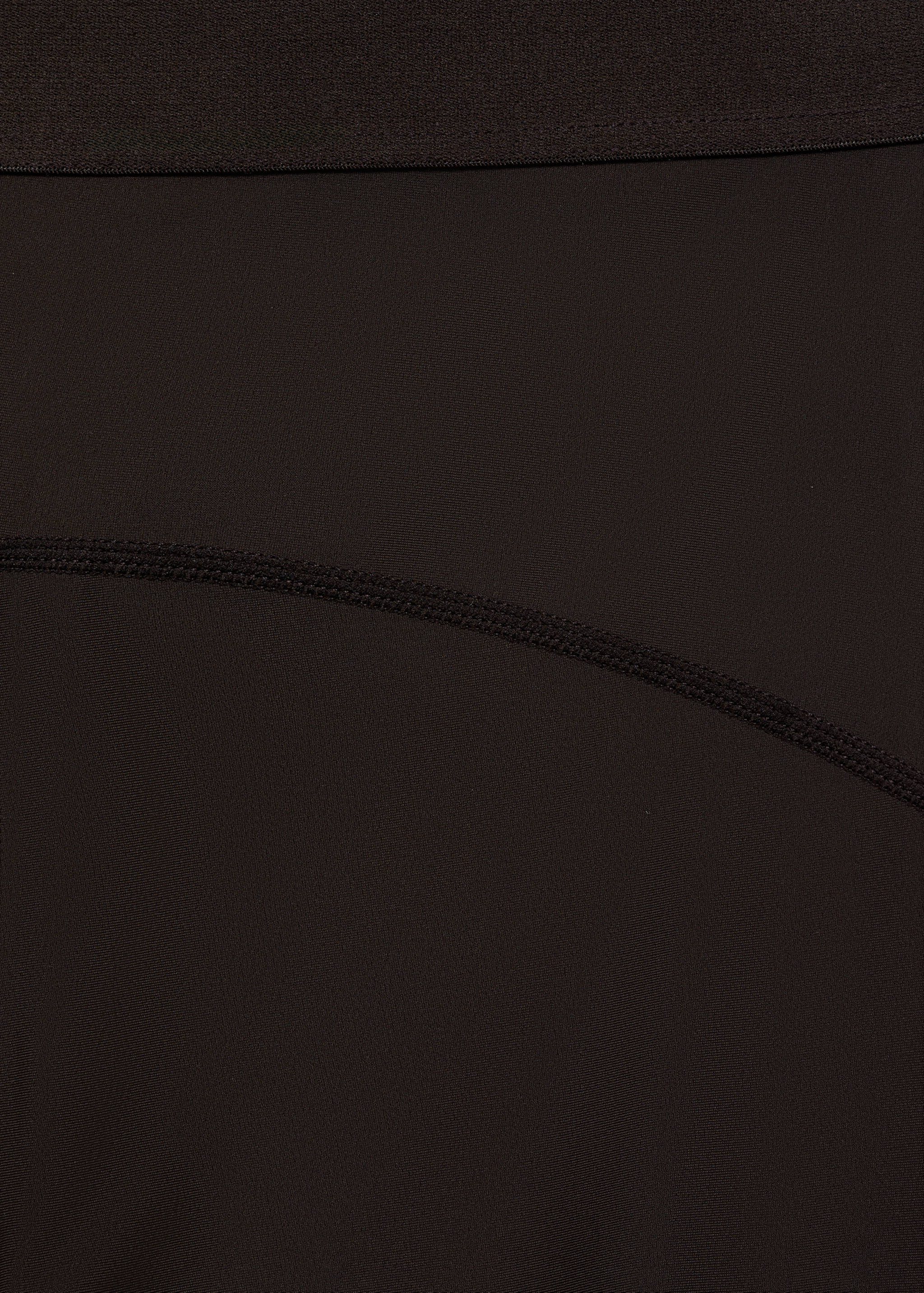 Close-up fabric detail of black leggings showing the waistband.