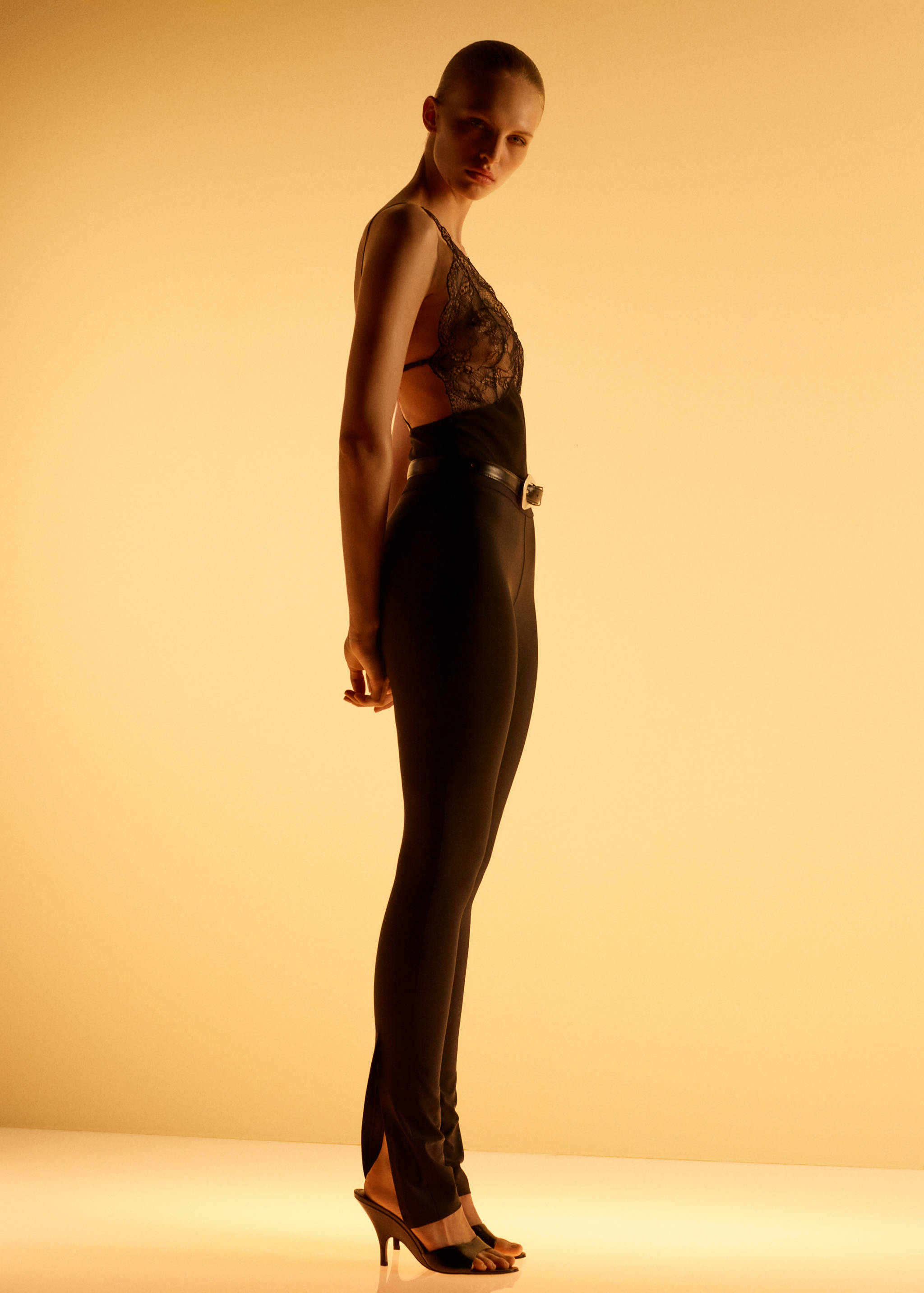 Black leggings with ankle slits, worn with a lace bodysuit.